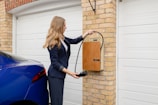 A woman in a business suit using an EV charger
