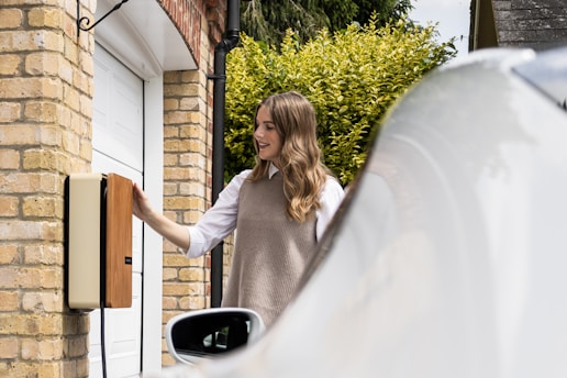 A woman opening the door of a white car