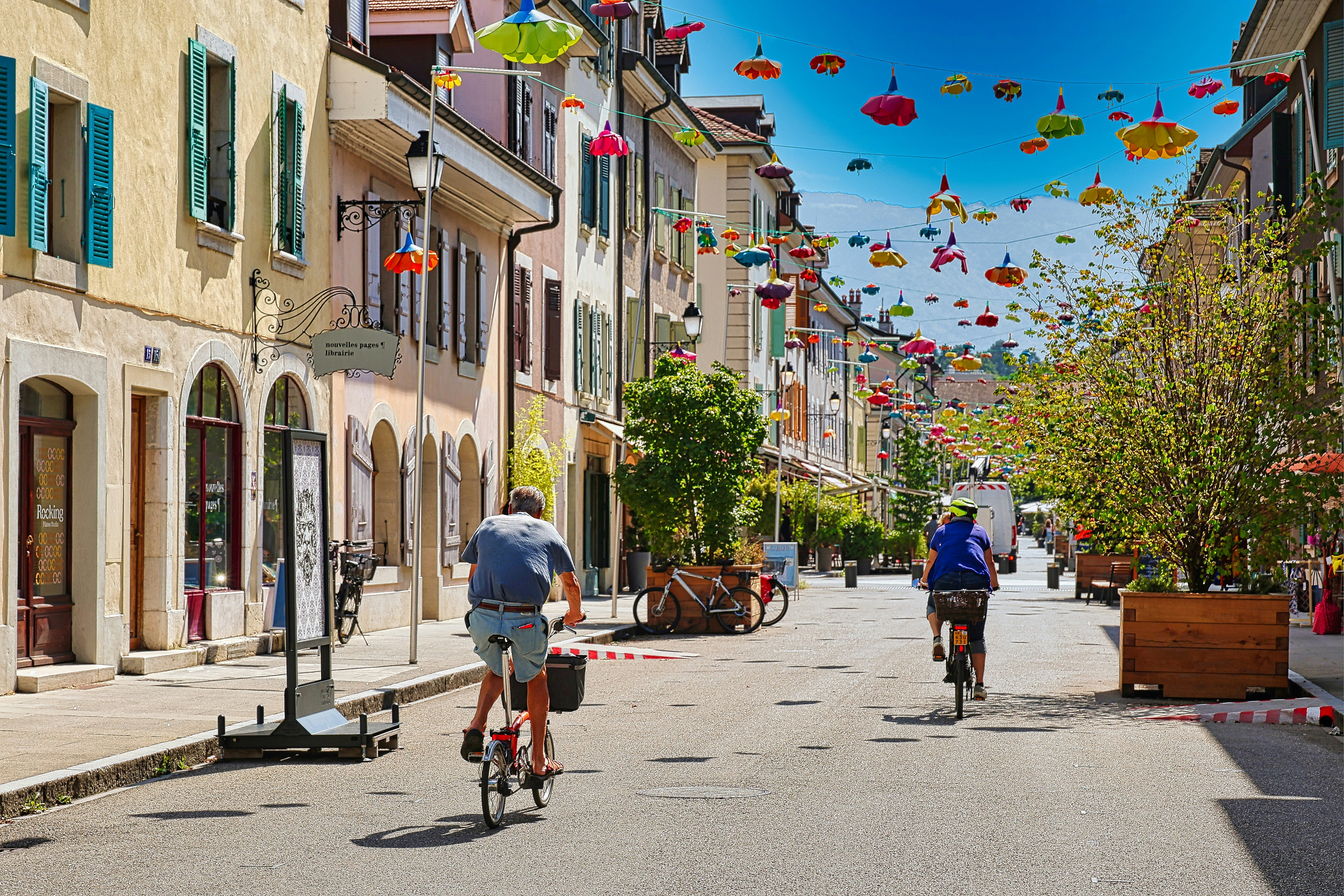 A couple of people riding bikes down a street