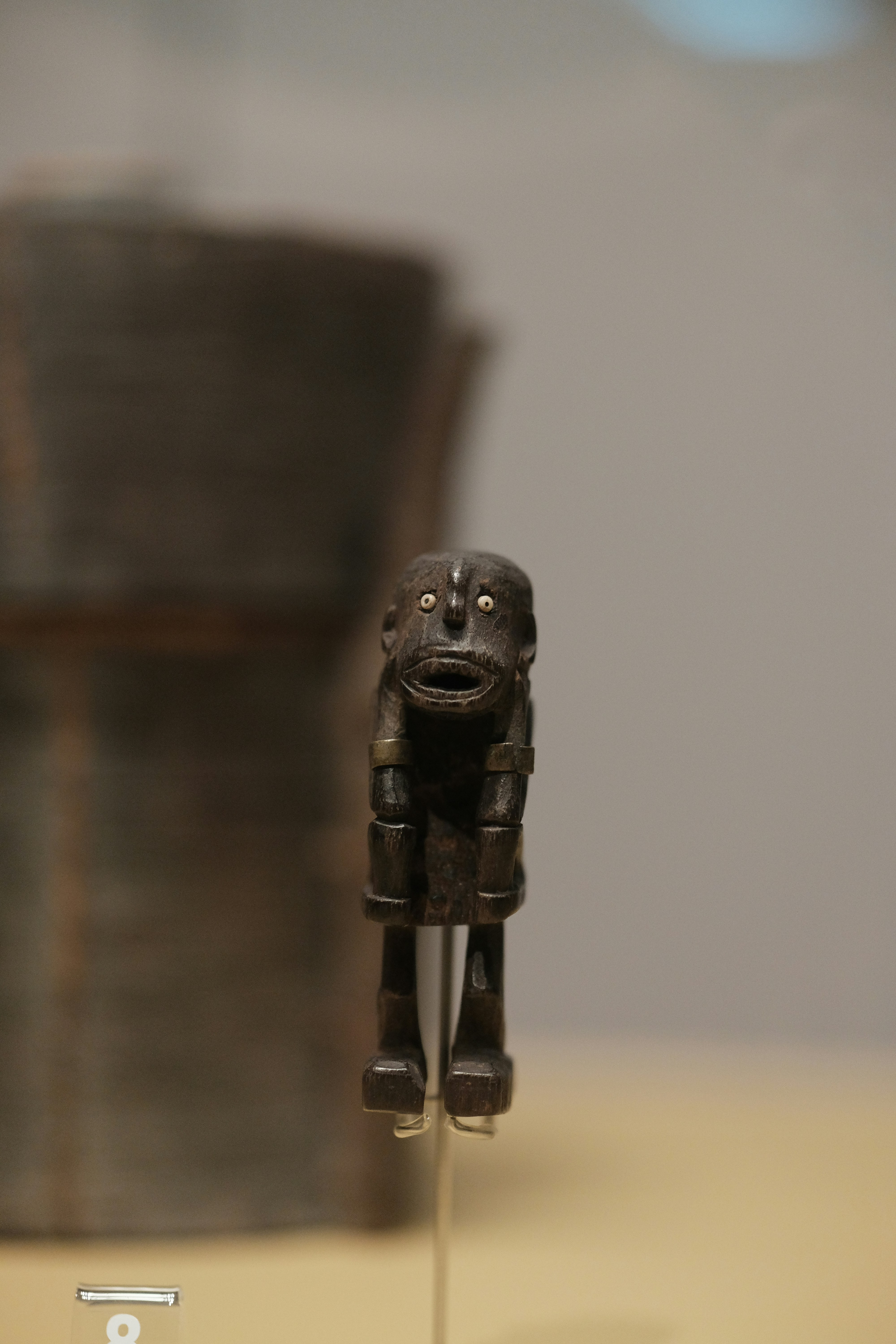 Eine kleine Holzfigur, die auf einem Tisch sitzt