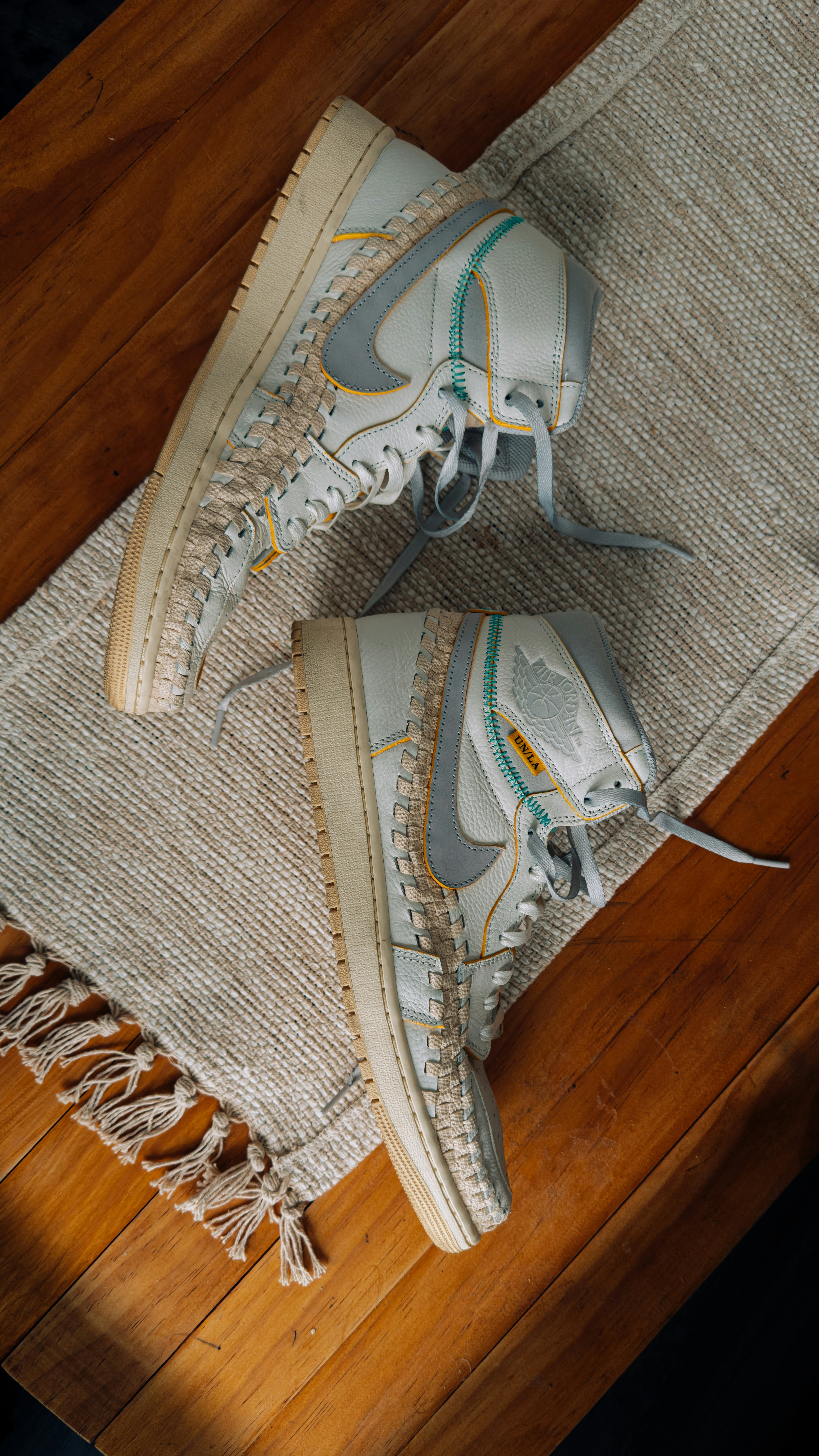 A pair of white sneakers sitting on top of a rug