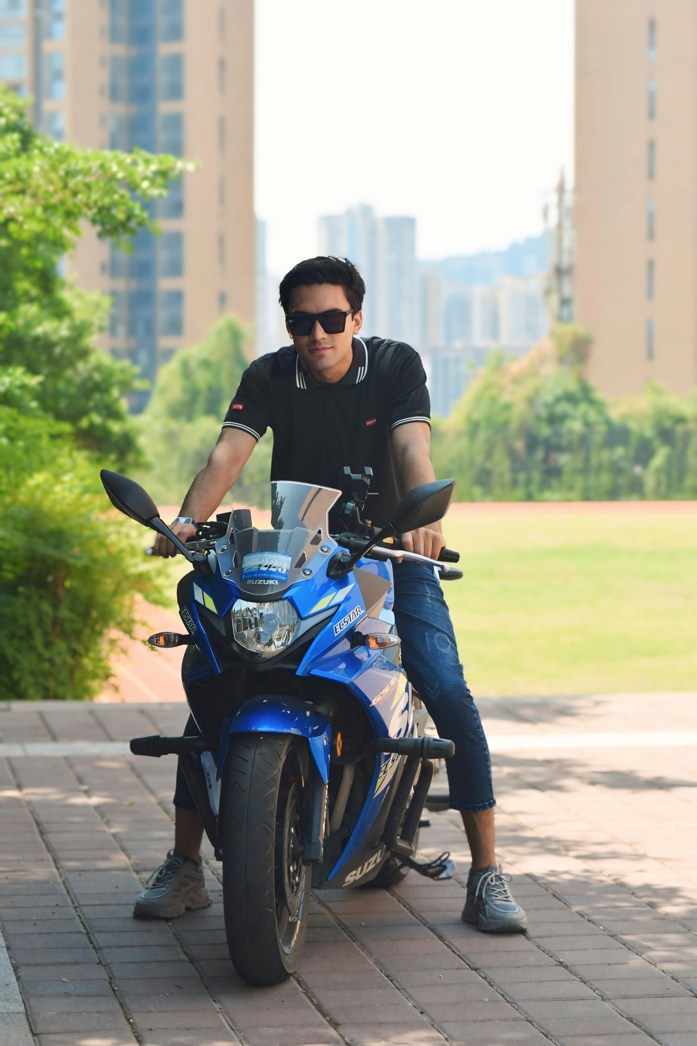 A man sitting on top of a blue motorcycle