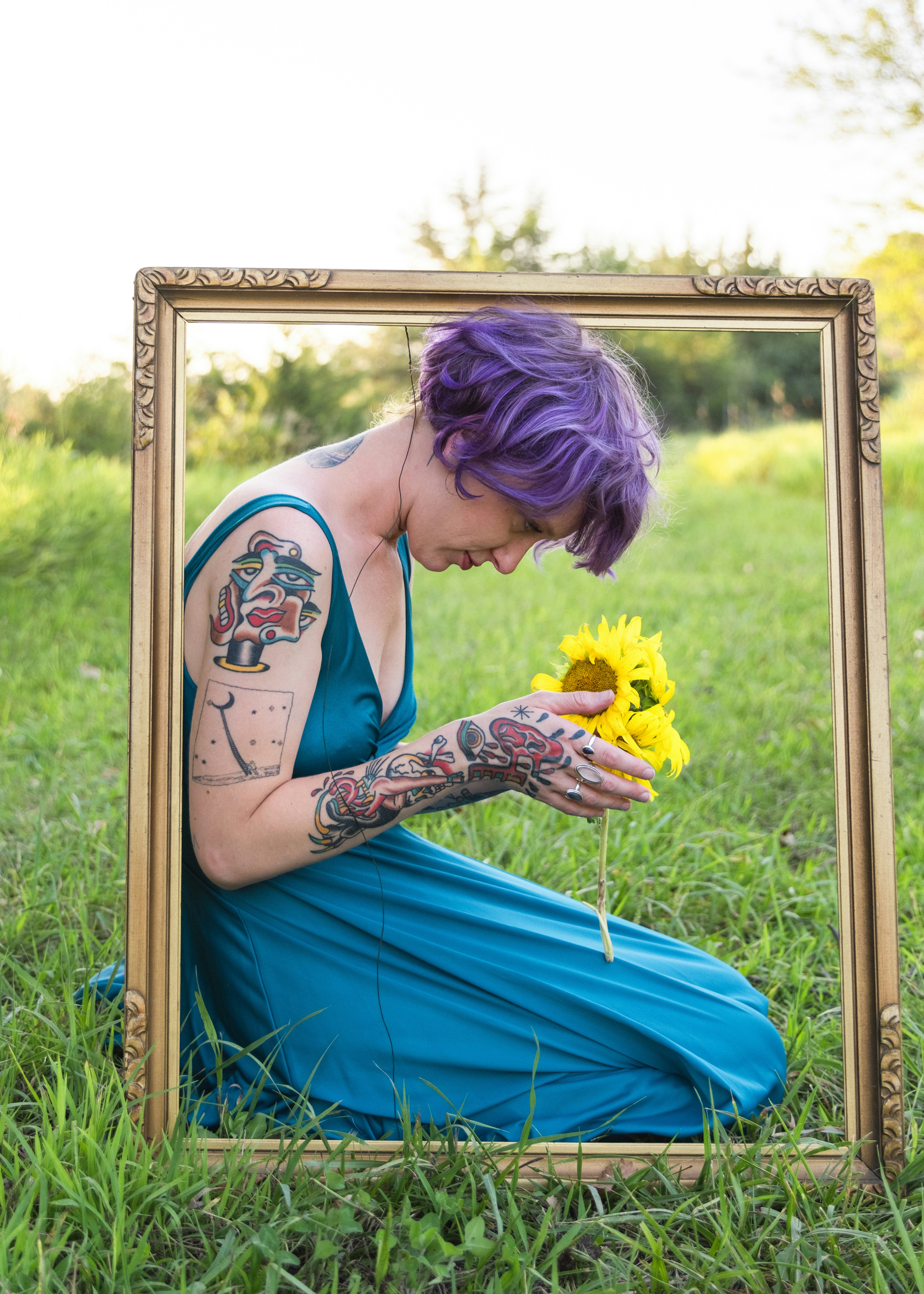 A woman in a blue dress holding a yellow flower