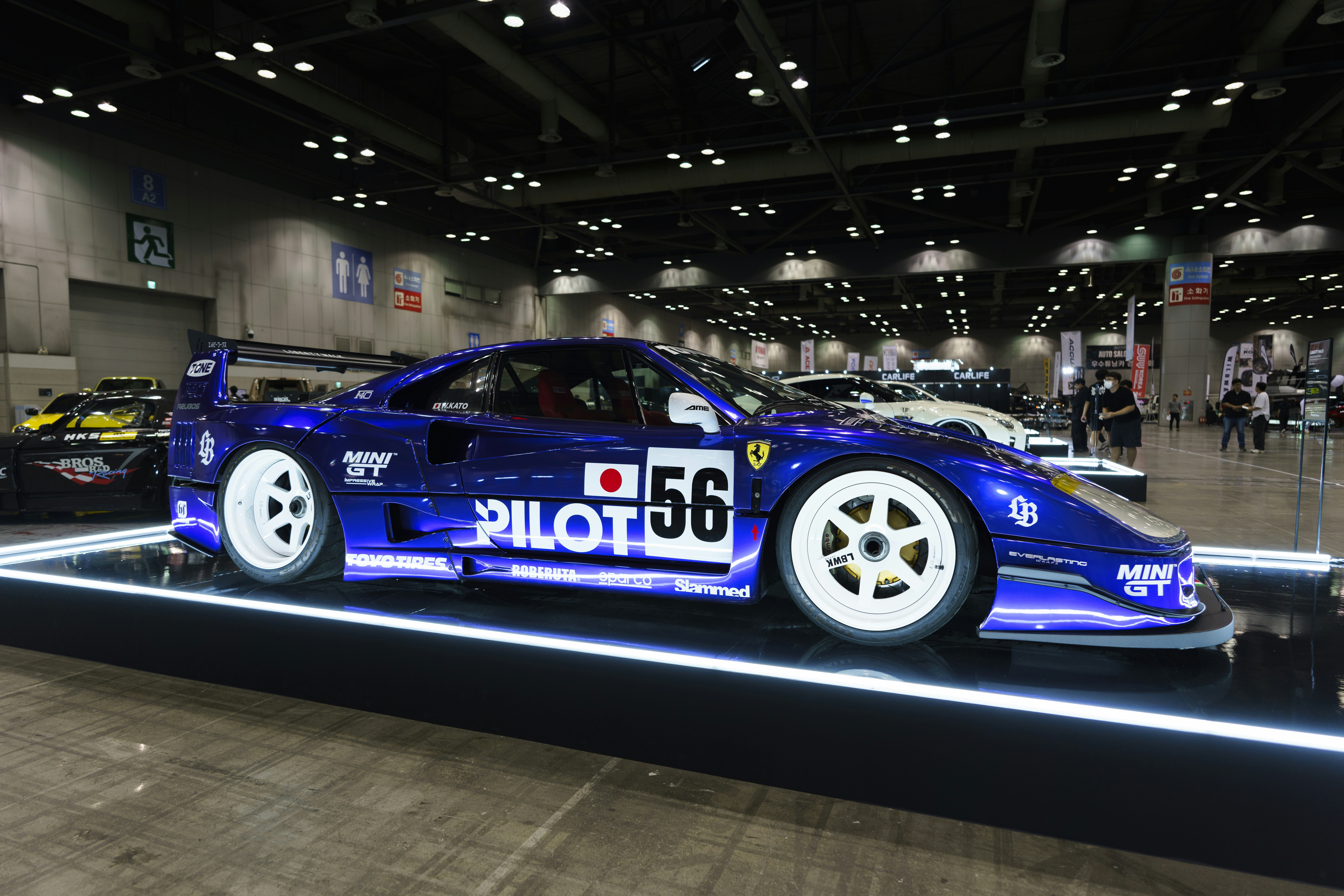 Blue race car displayed in neon-lit virtual garage