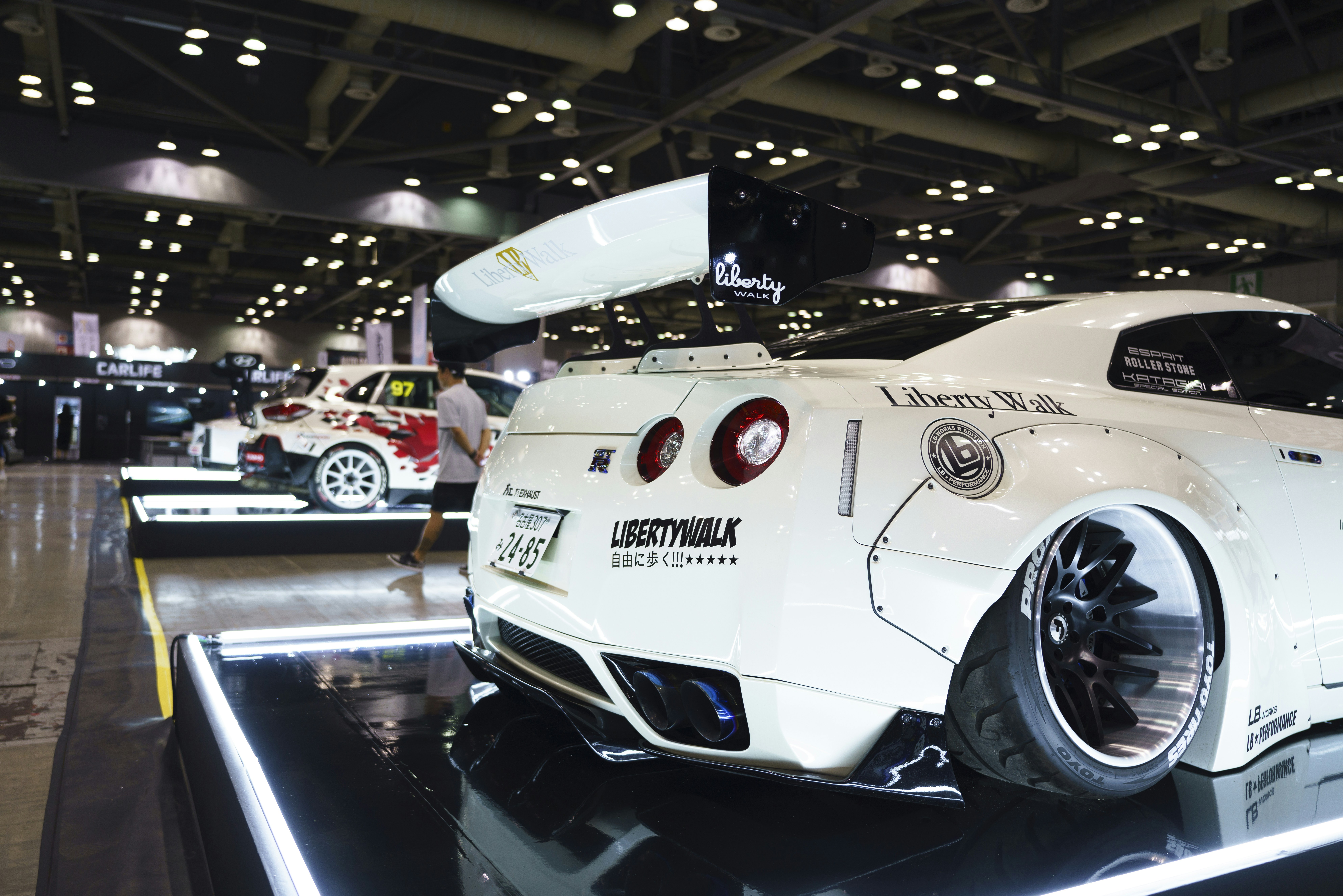 A white sports car on display in a showroom