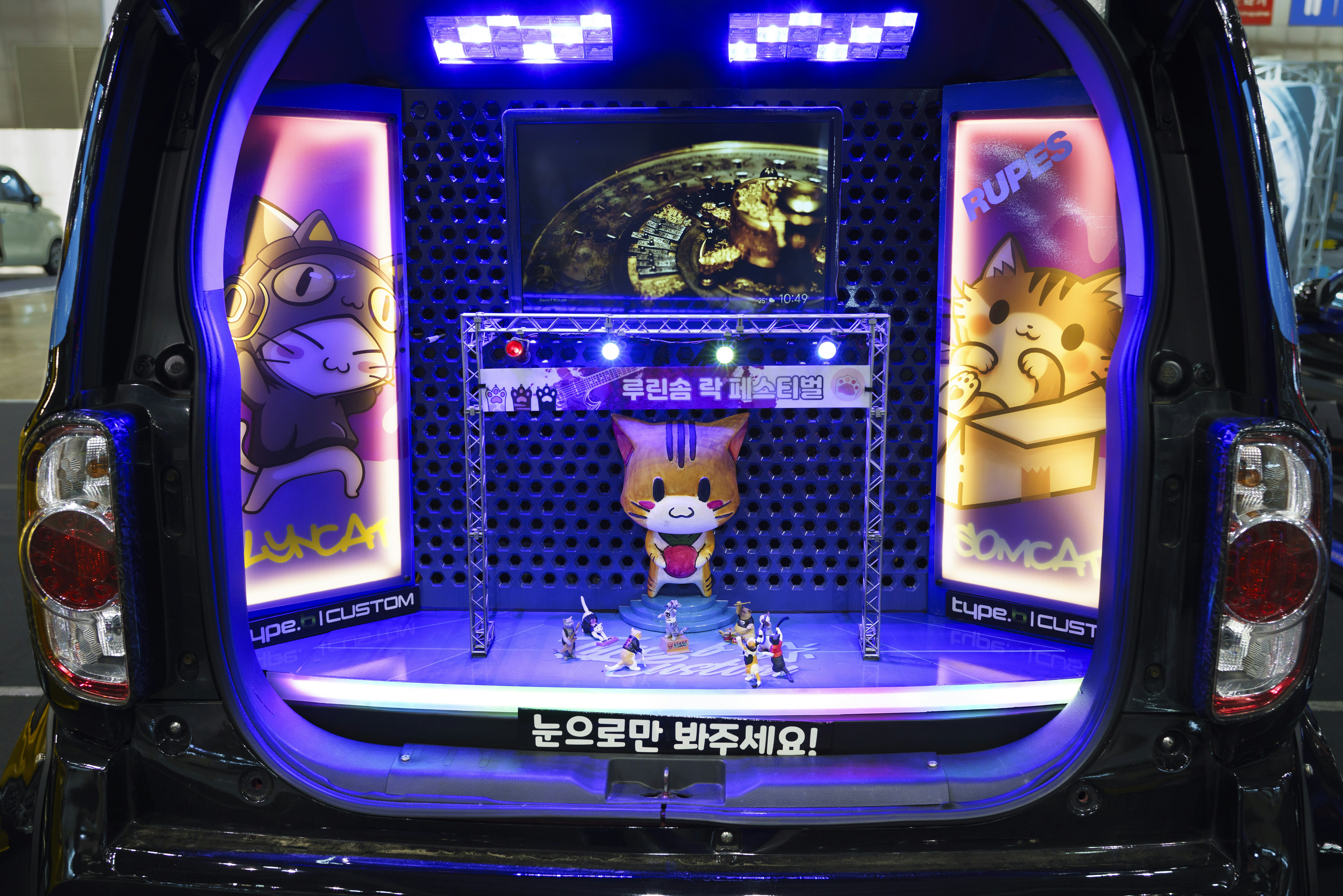 The back end of a car with a game system in the trunk