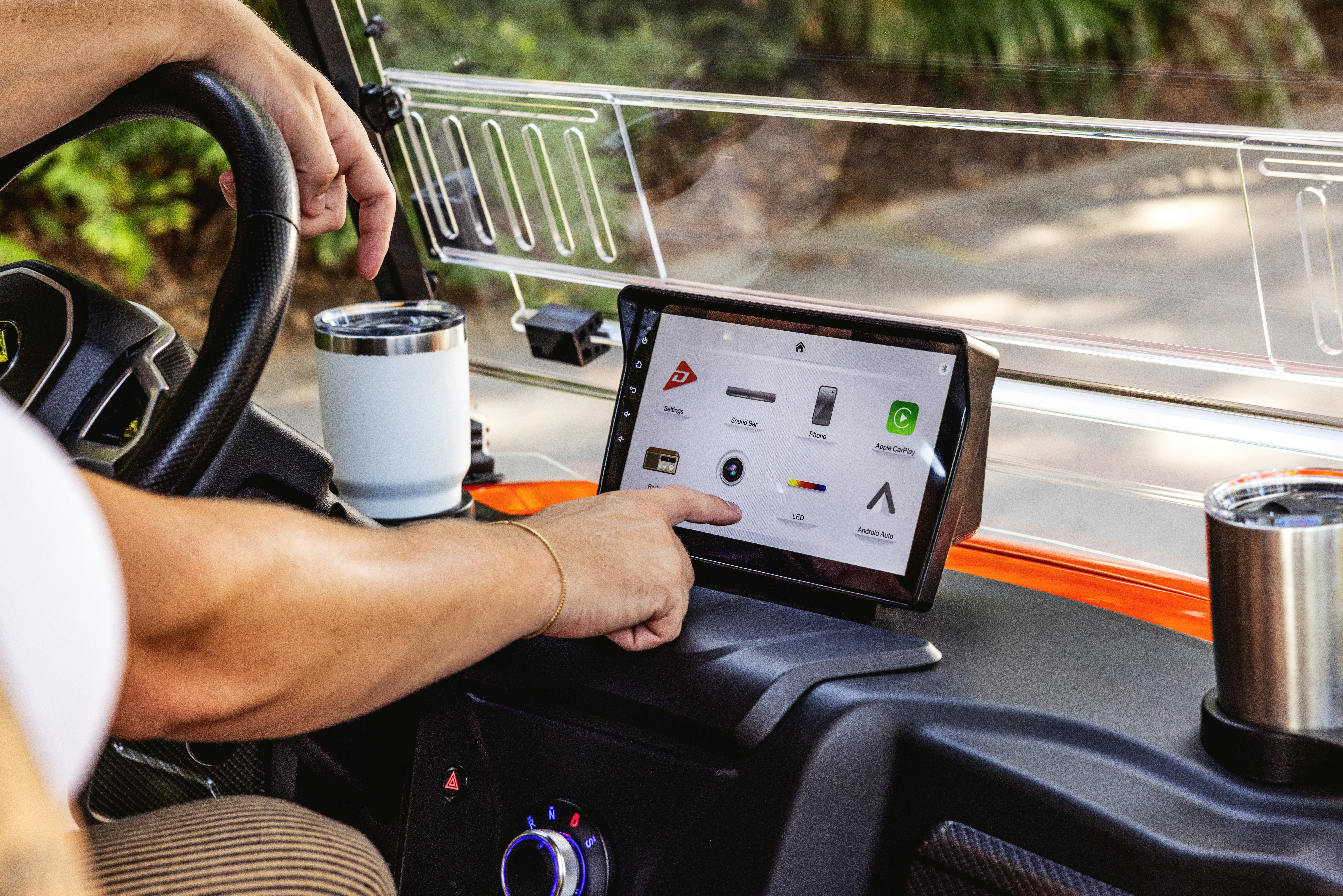 A man driving a bus with a tablet on his lap