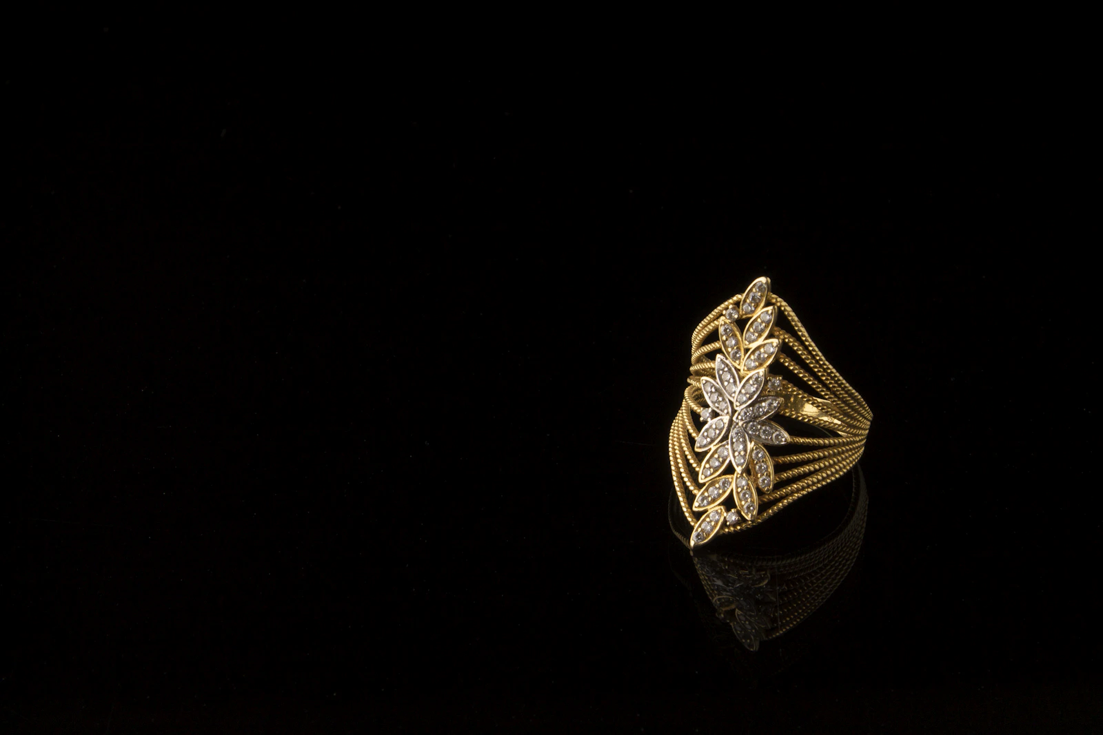 Gold diamond ring on black background