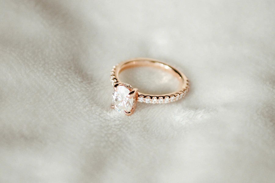 Rose gold diamond engagement ring resting on white silk