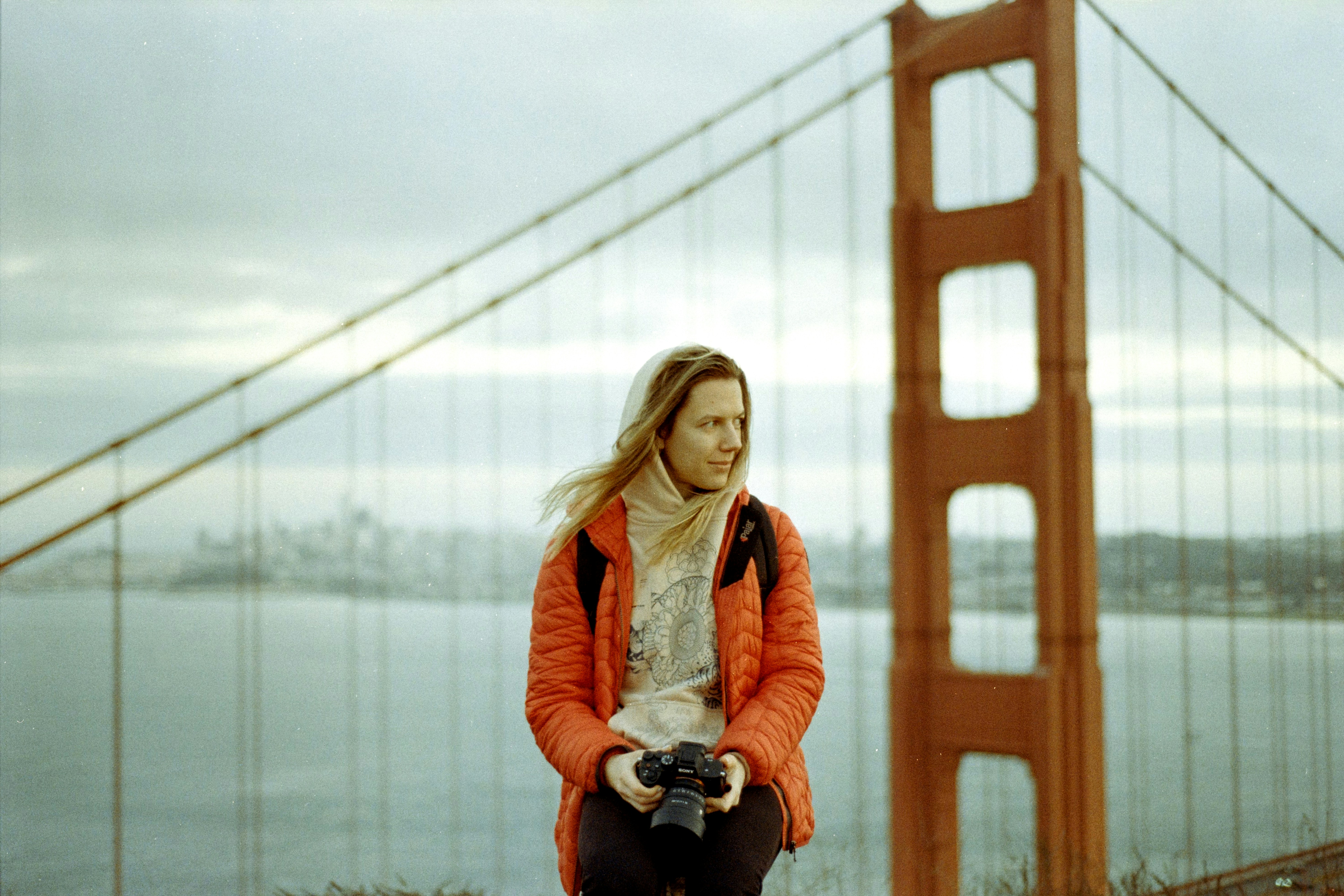 A woman standing in front of the golden gate bridge