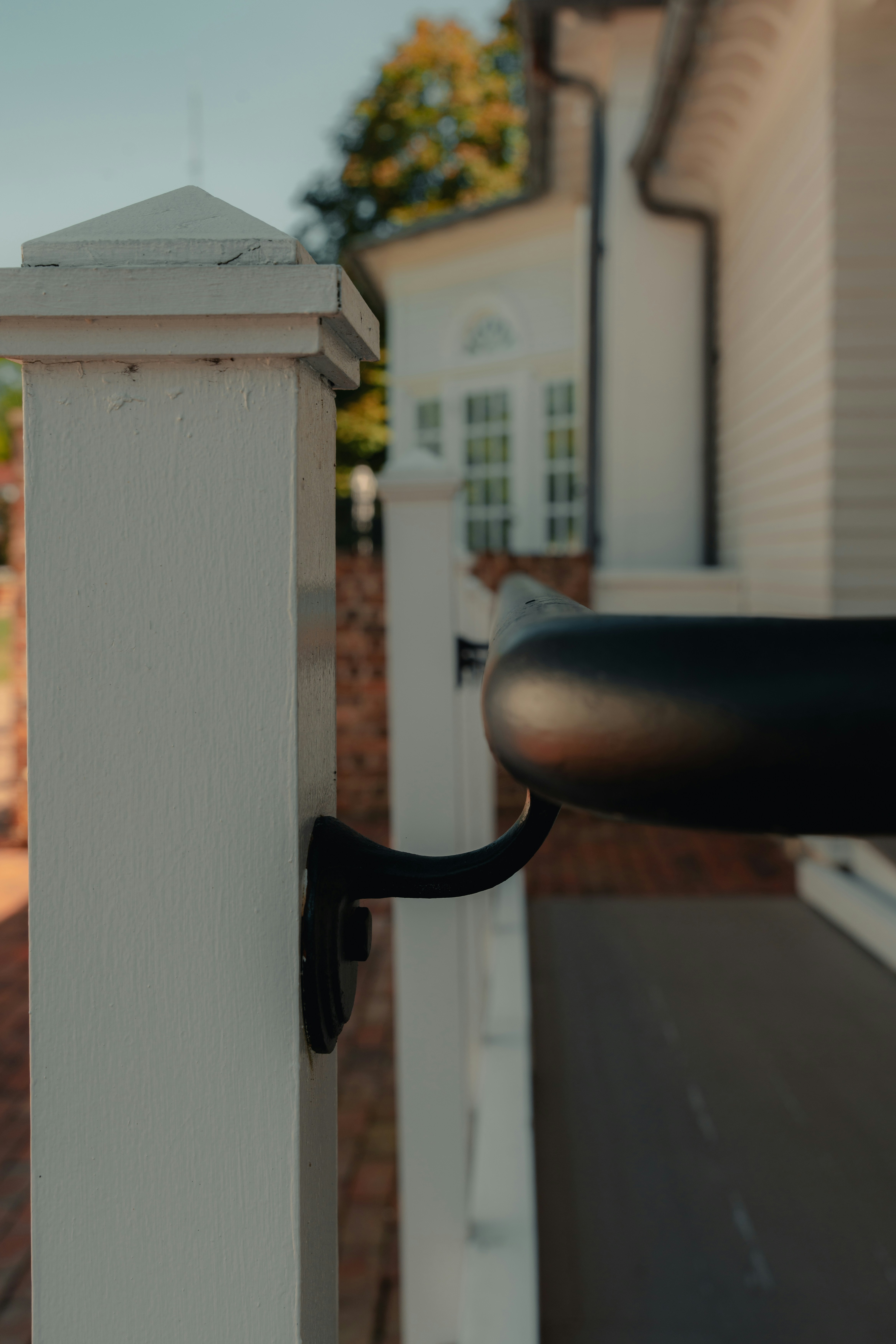 A white fence post cap and rail joint seen close up