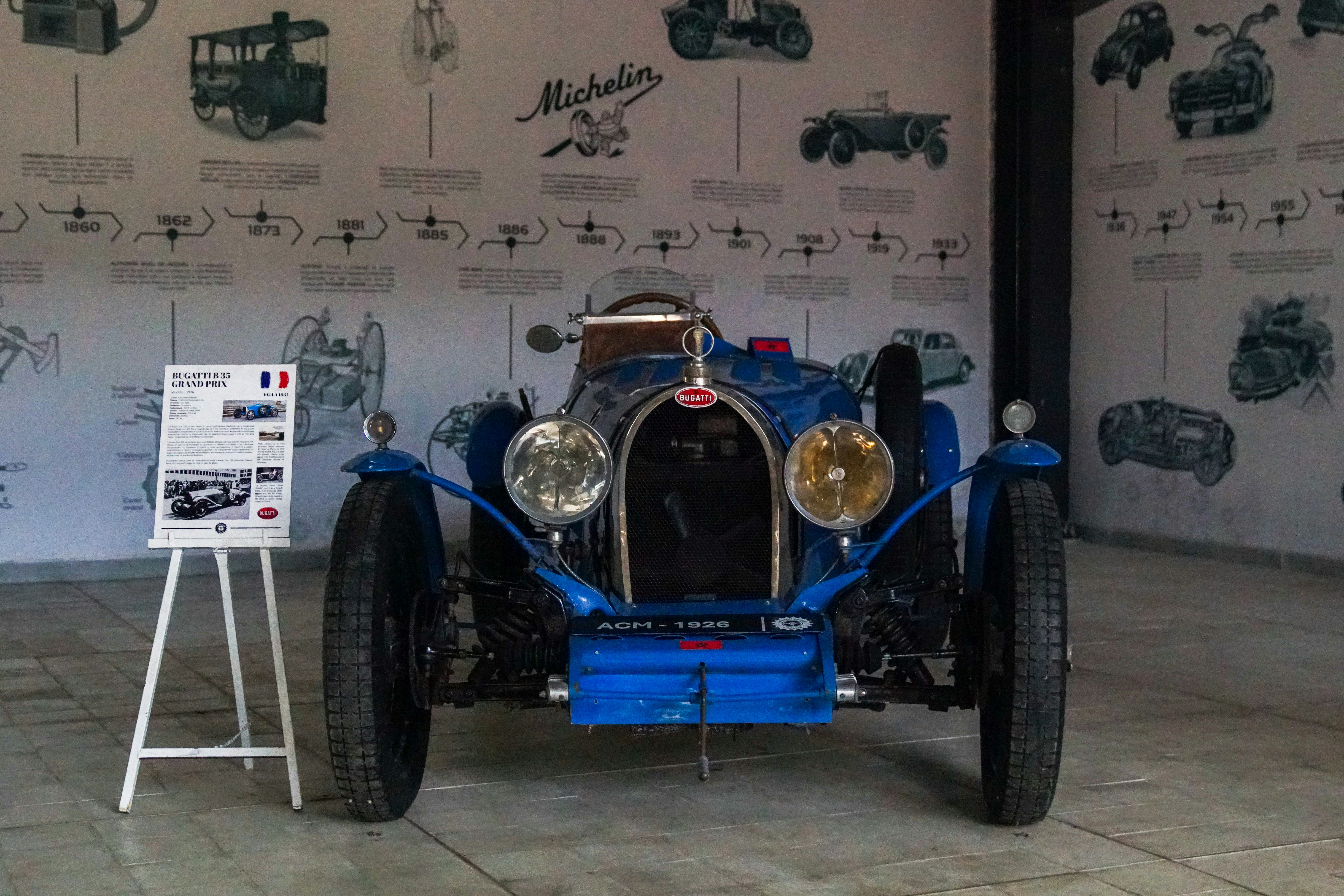 A blue race car is on display in a museum