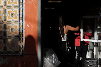 A man in a red shirt is standing in a doorway