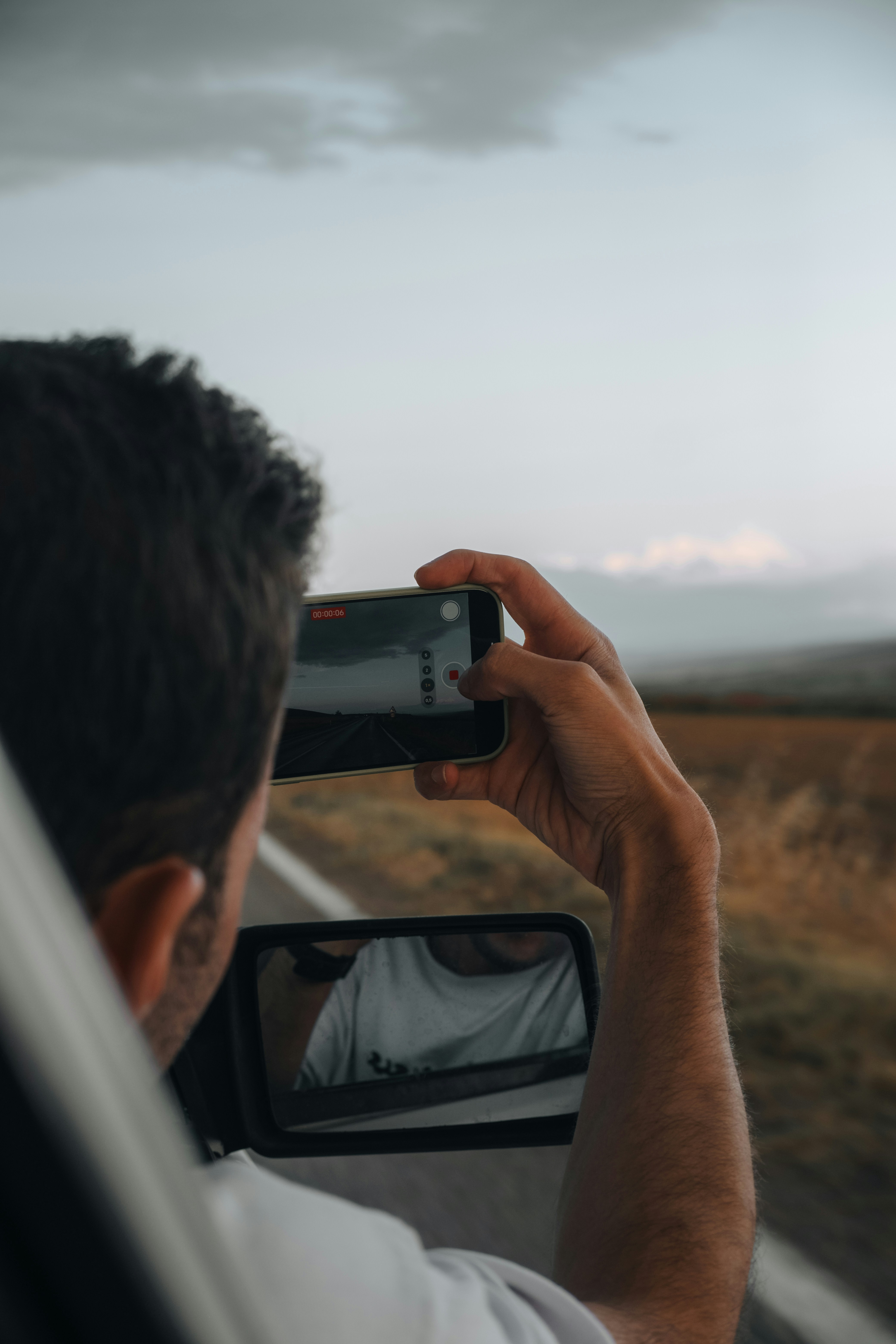 A man taking a picture of himself in a car mirror