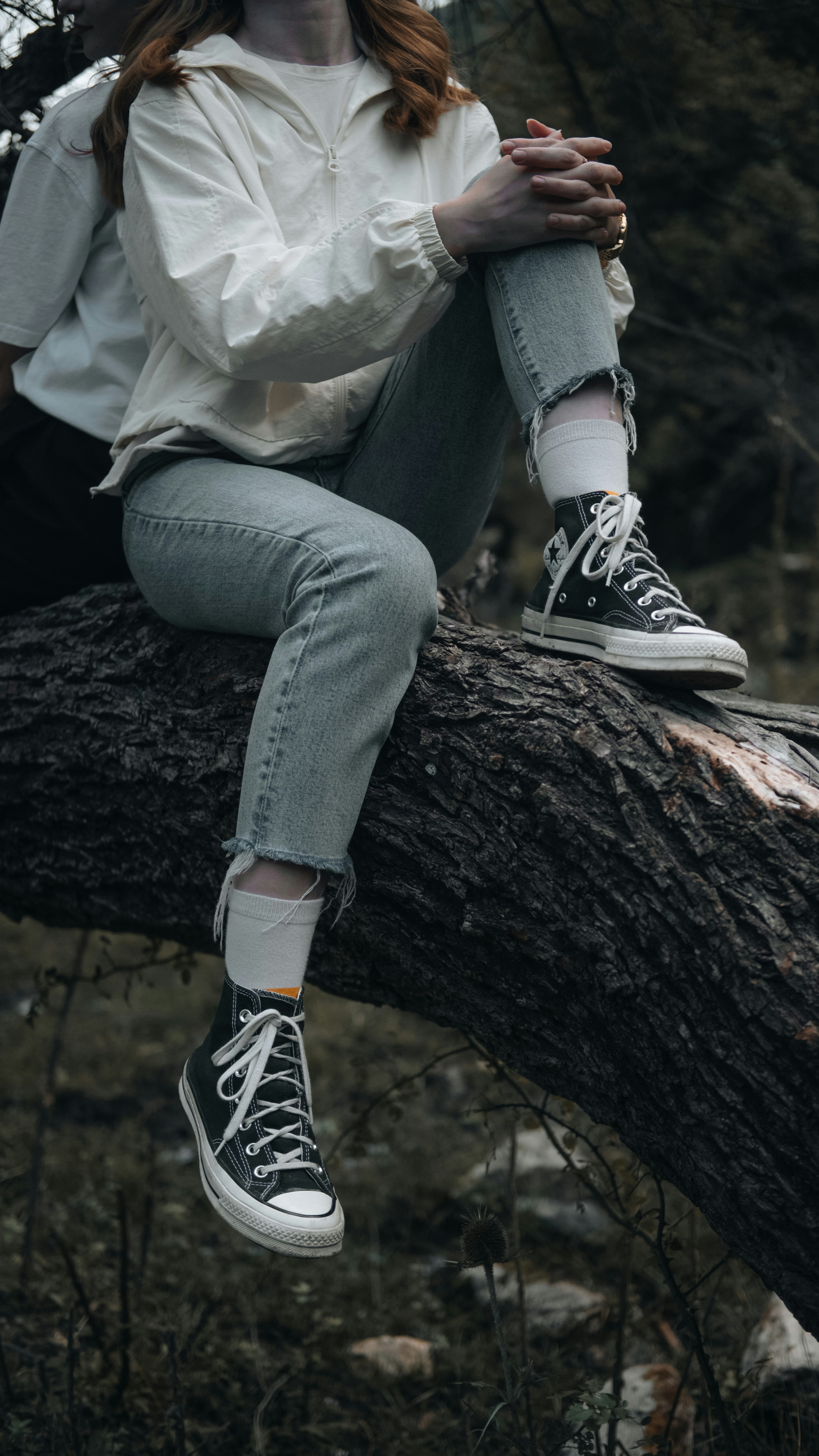 A woman sitting on top of a tree branch