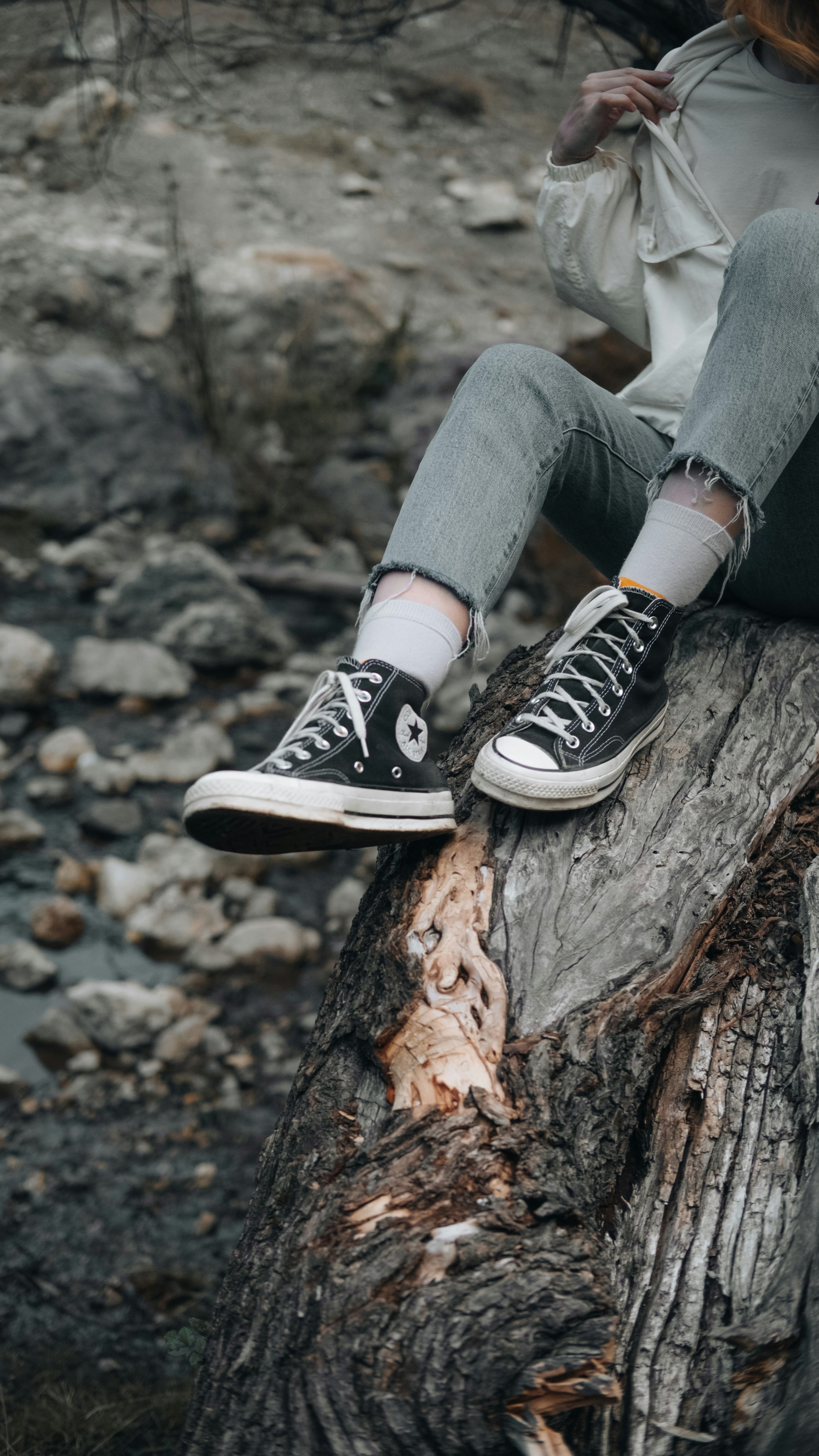 A person sitting on top of a tree stump