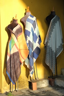 A couple of different colored towels hanging on a wall