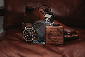 A pair of brown shoes sitting on top of a bed