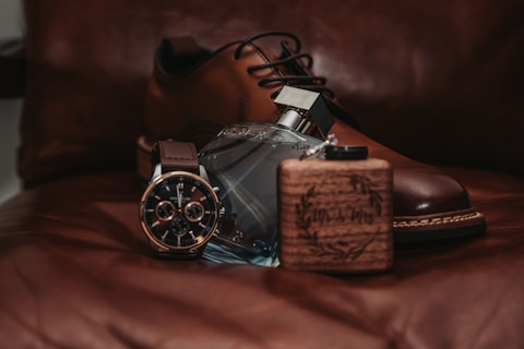A pair of brown shoes sitting on top of a bed