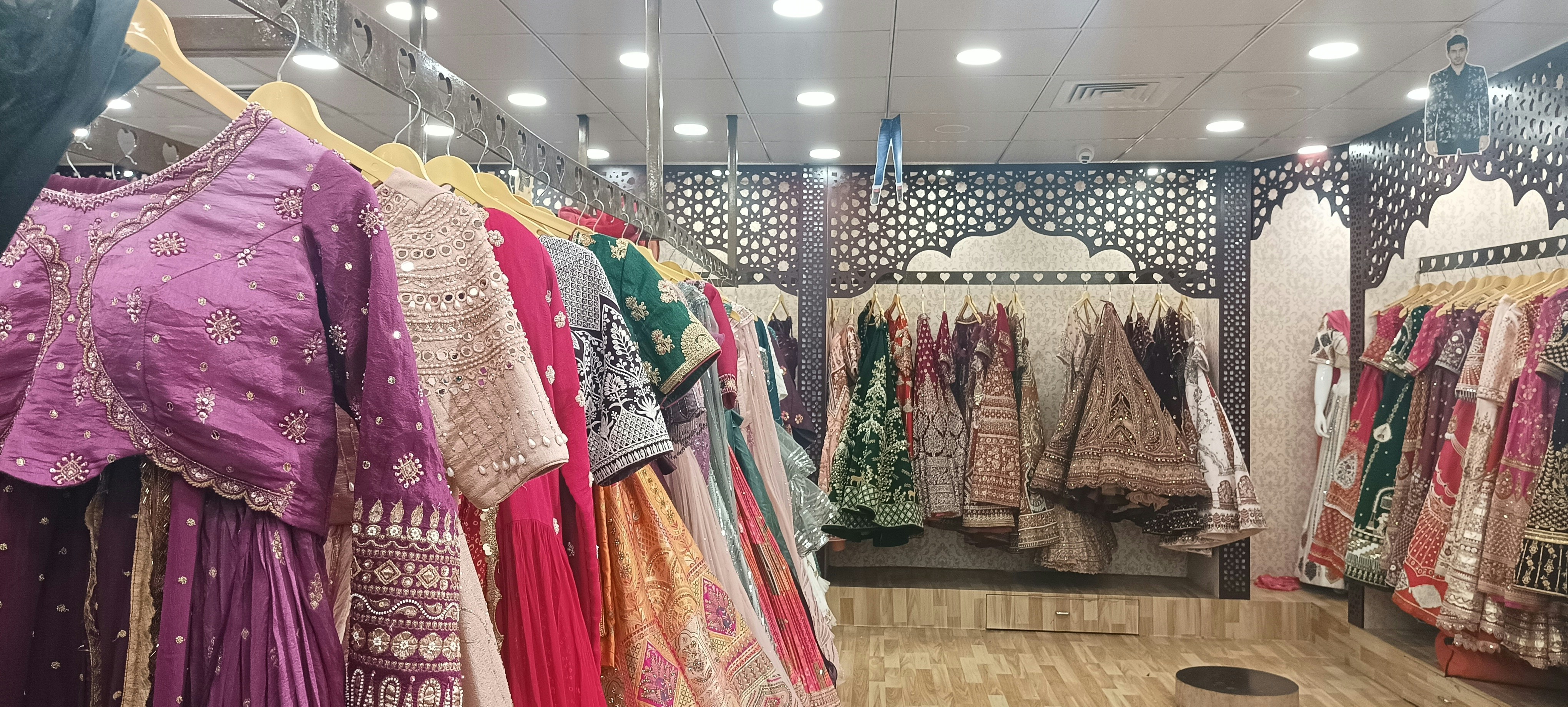 Traditional Indian ethnic wear collection with embroidered salwar suits and dupattas in a boutique display