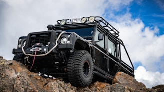 A black jeep is parked on a rock