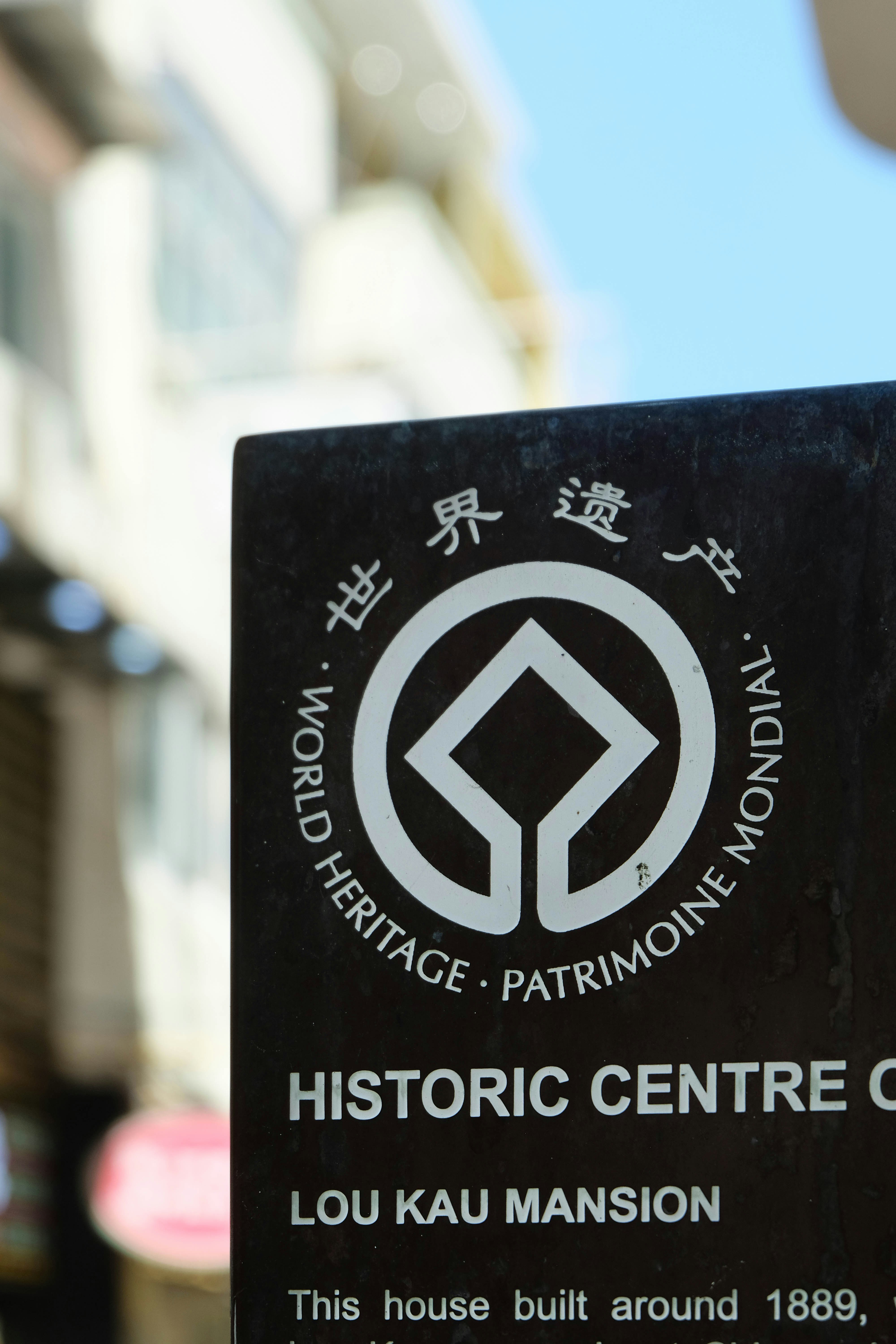 A close up of a sign with a building in the background