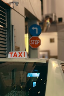 A taxi cab parked next to a stop sign