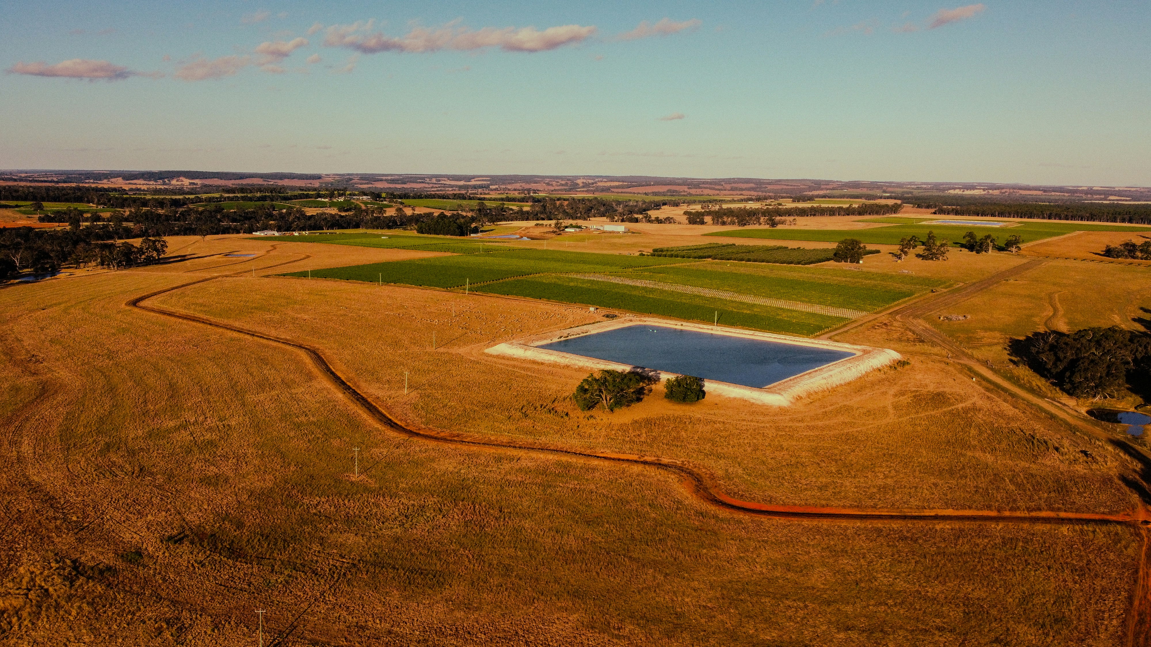 An aerial view of a field with a pond