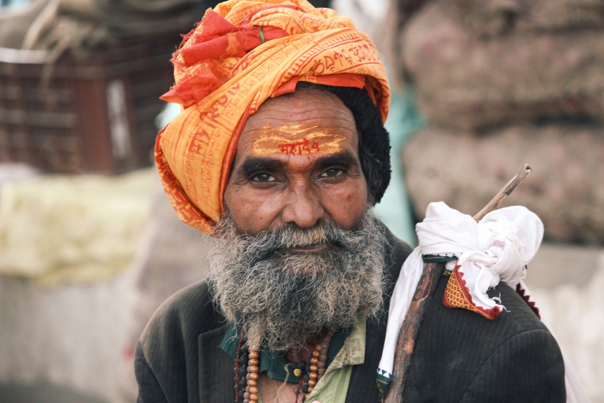 A man in a turban with a bird on his shoulder