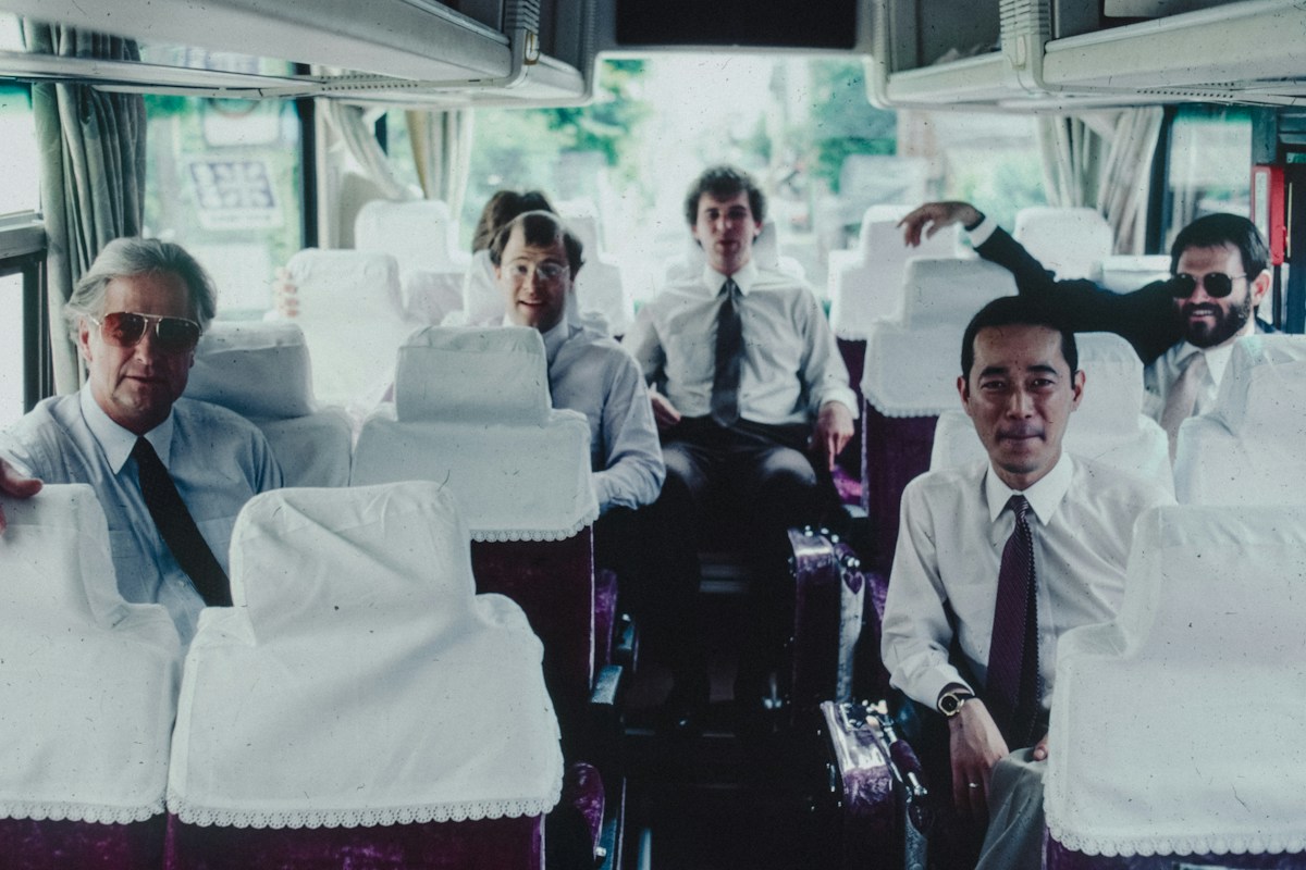 A group of male athletes sitting on top of a bus, engaging in team bonding conversation starters.