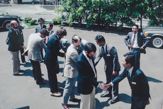 A group of men standing around each other in a parking lot
