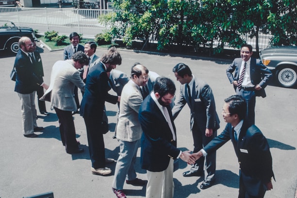A group of men standing around each other in a parking lot