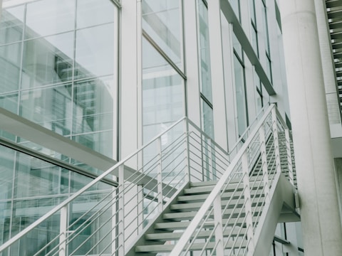 A metal hand rail next to a glass building