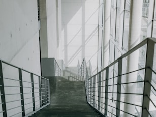 A long hallway with metal railings leading up to a building