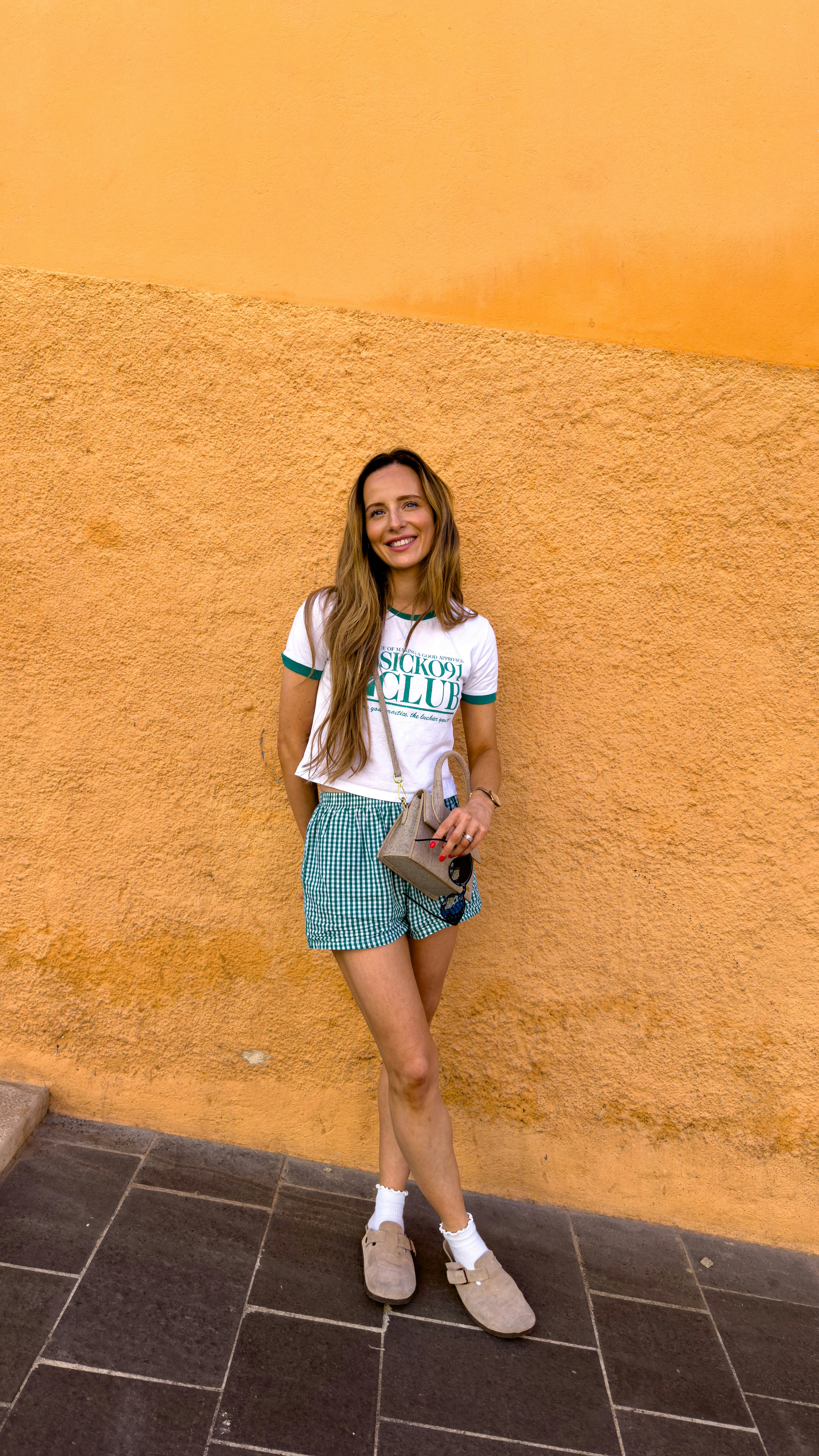A woman standing in front of a yellow wall