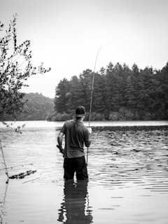 A man standing in the water with a fishing pole