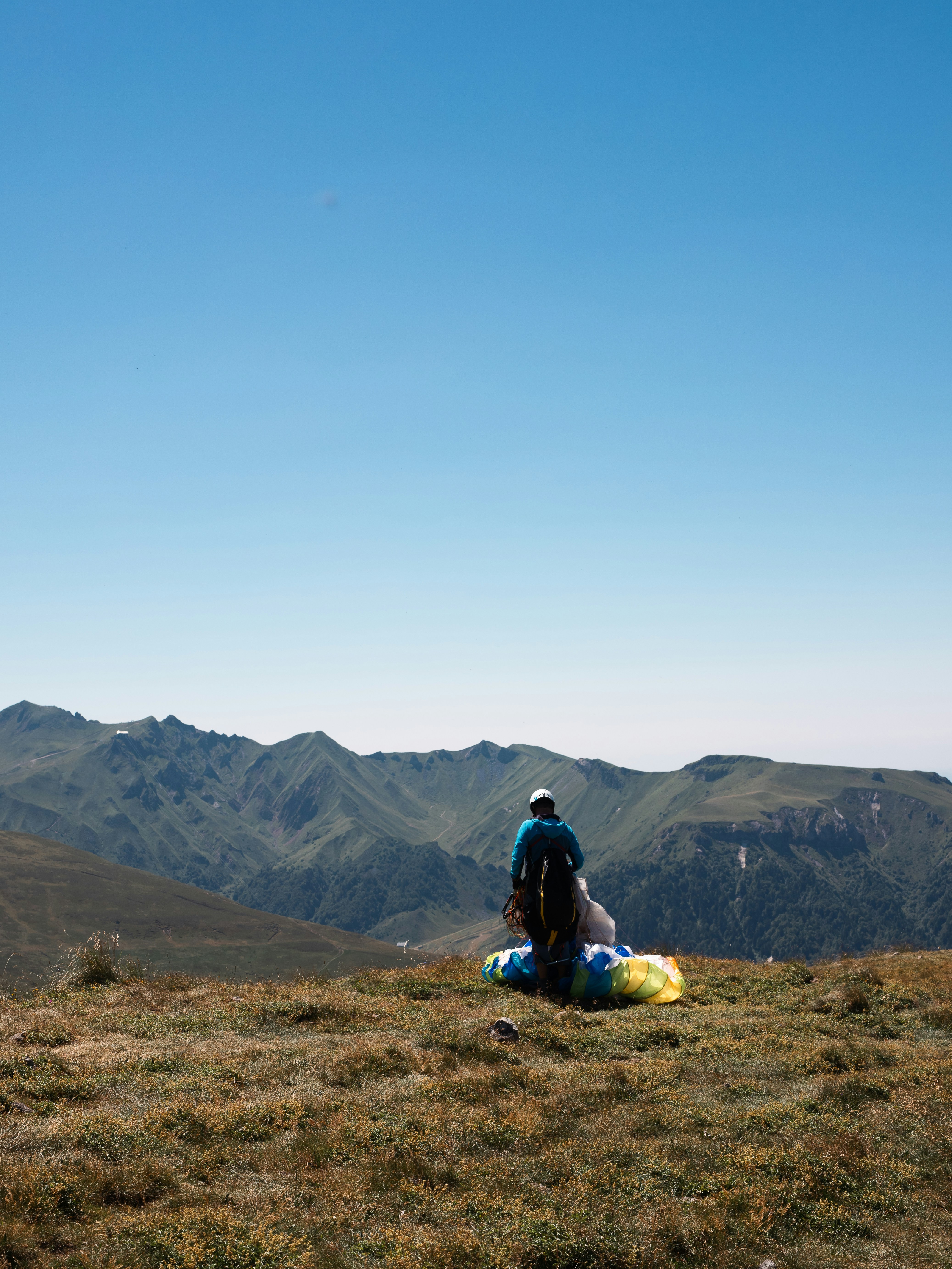 A man sitting on top of a grass covered hillside