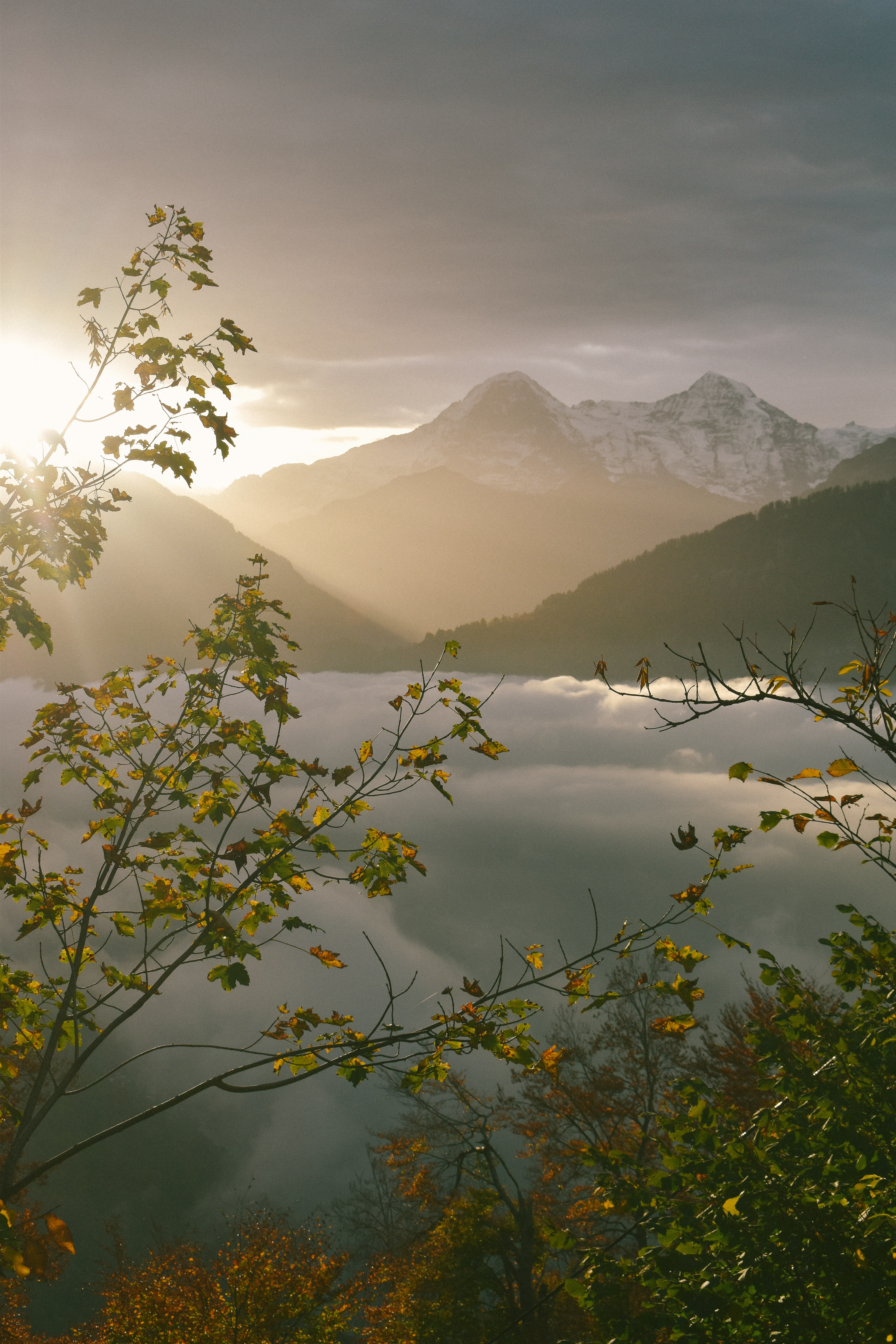 The sun shines through the clouds in the mountains