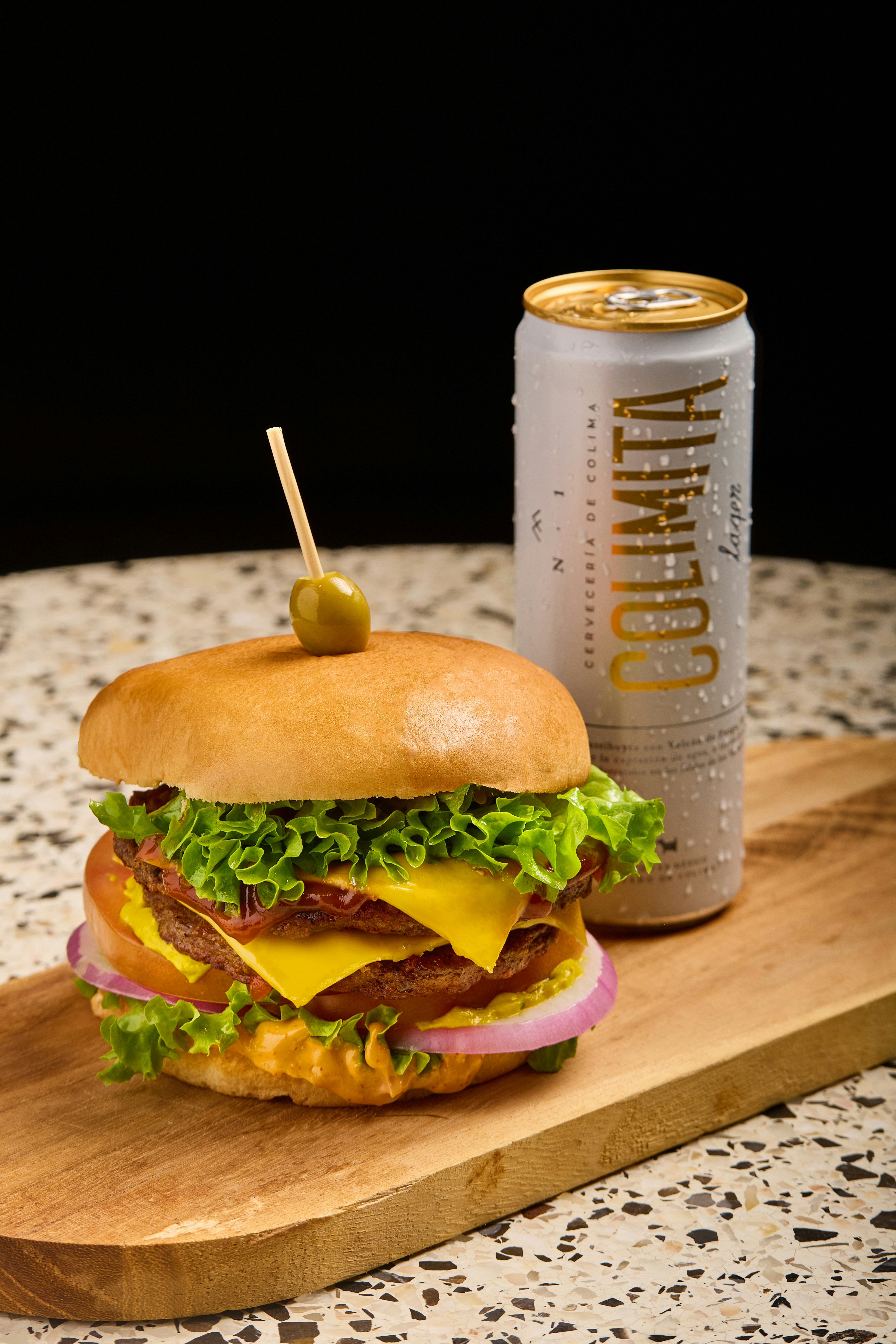 A cheeseburger with bacon, lettuce, and a pickle on