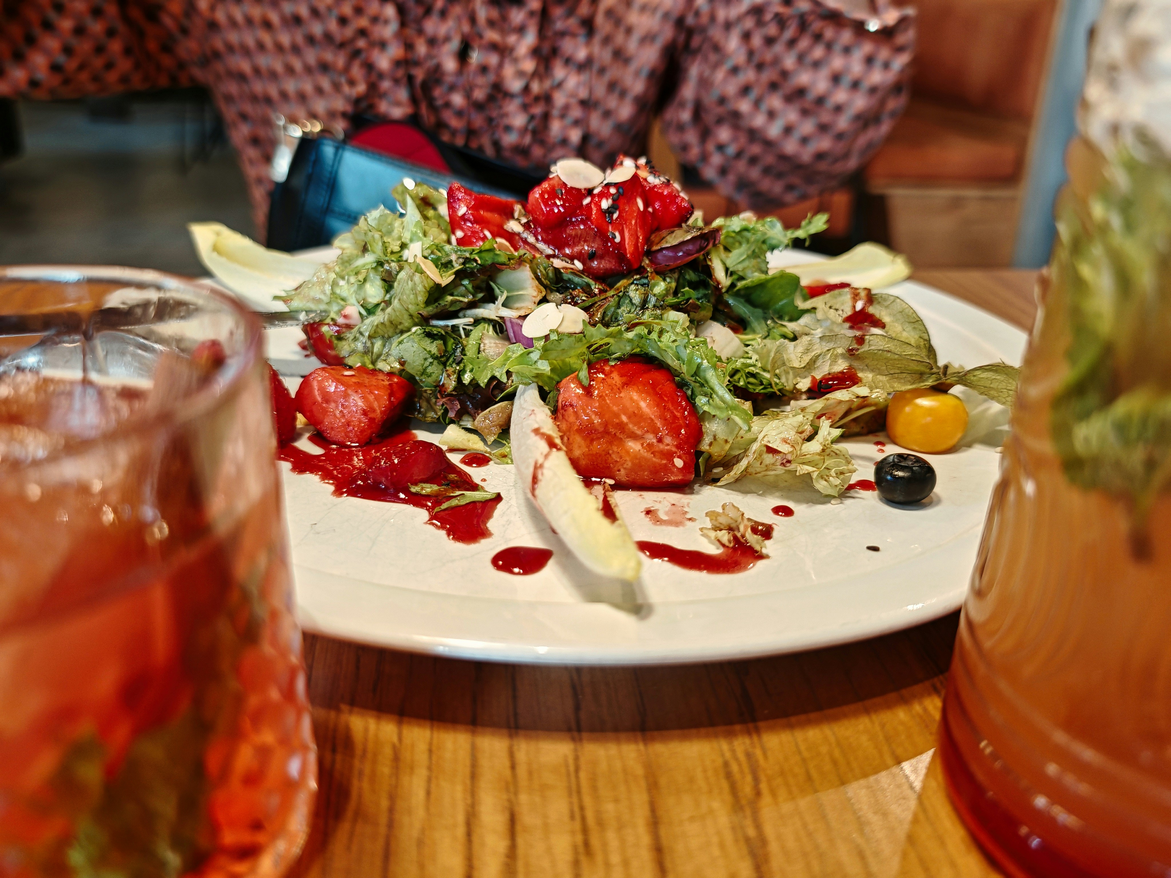 Fresh summer salad with colorful vegetables, berries, and vinaigrette dressing