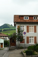 A white house with brown shutters on a street corner