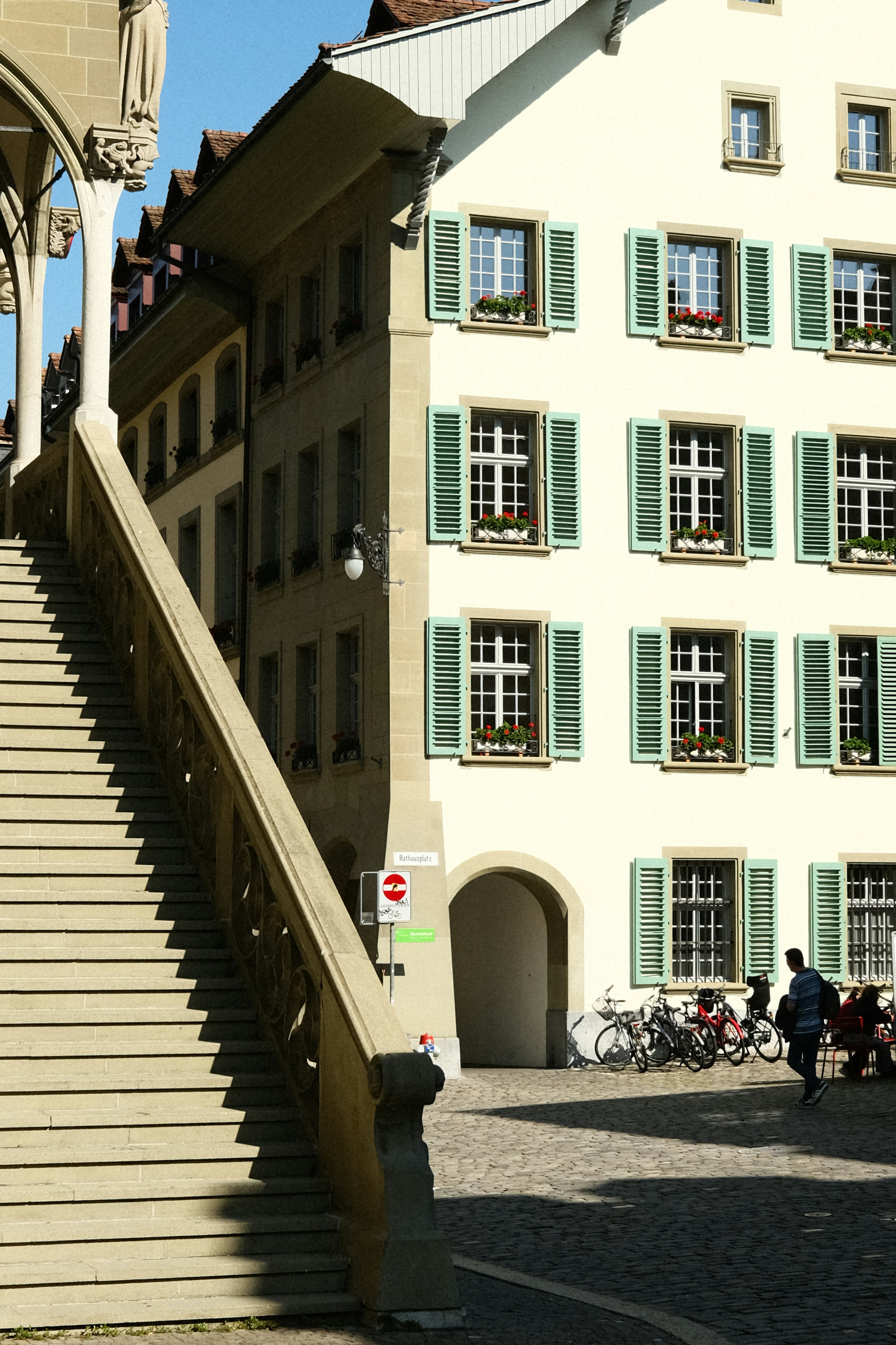 Un edificio con persianas verdes y una torre del reloj