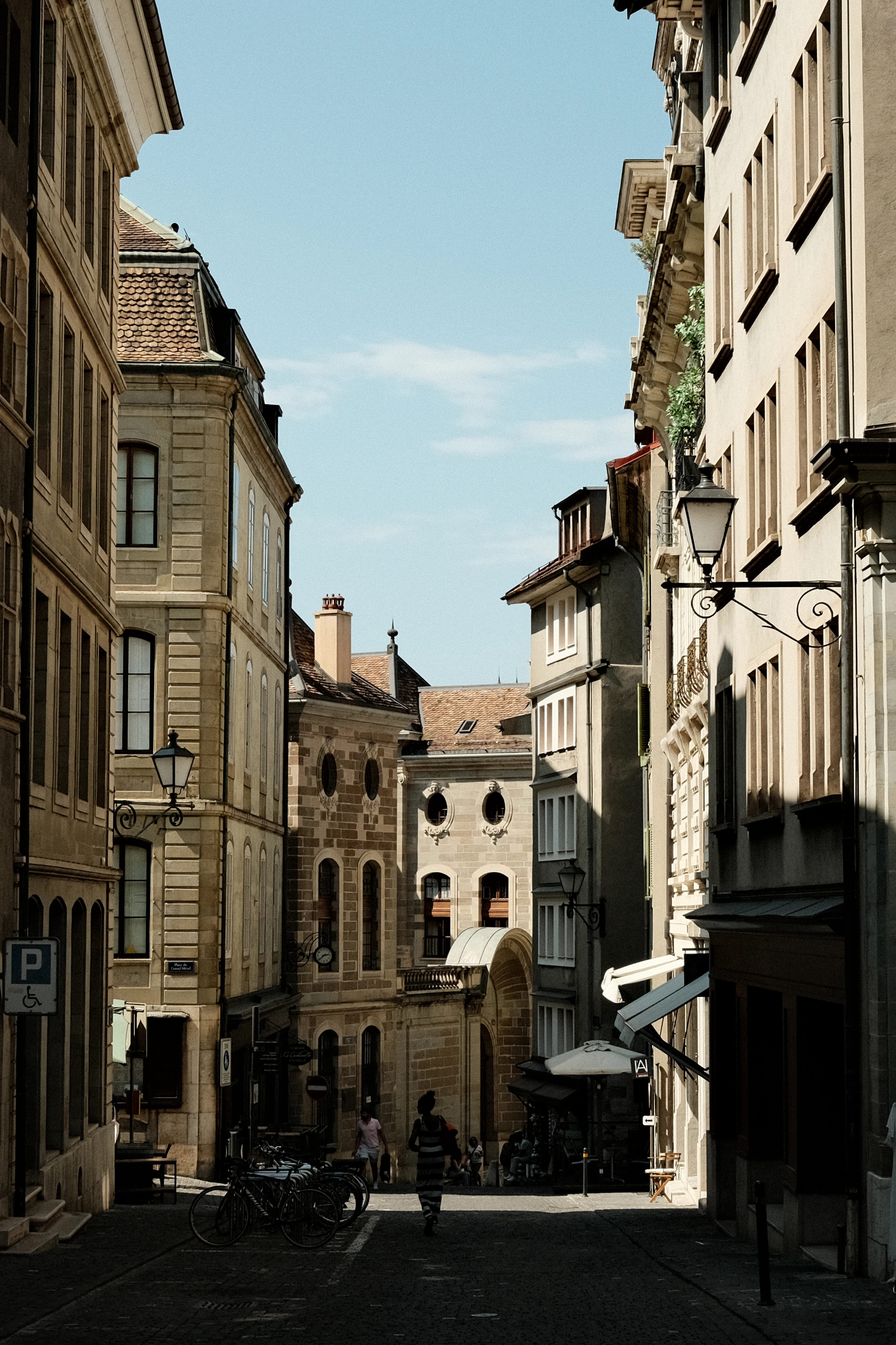 A quiet cobblestone street lined with lanterns winds through Geneva's old town.