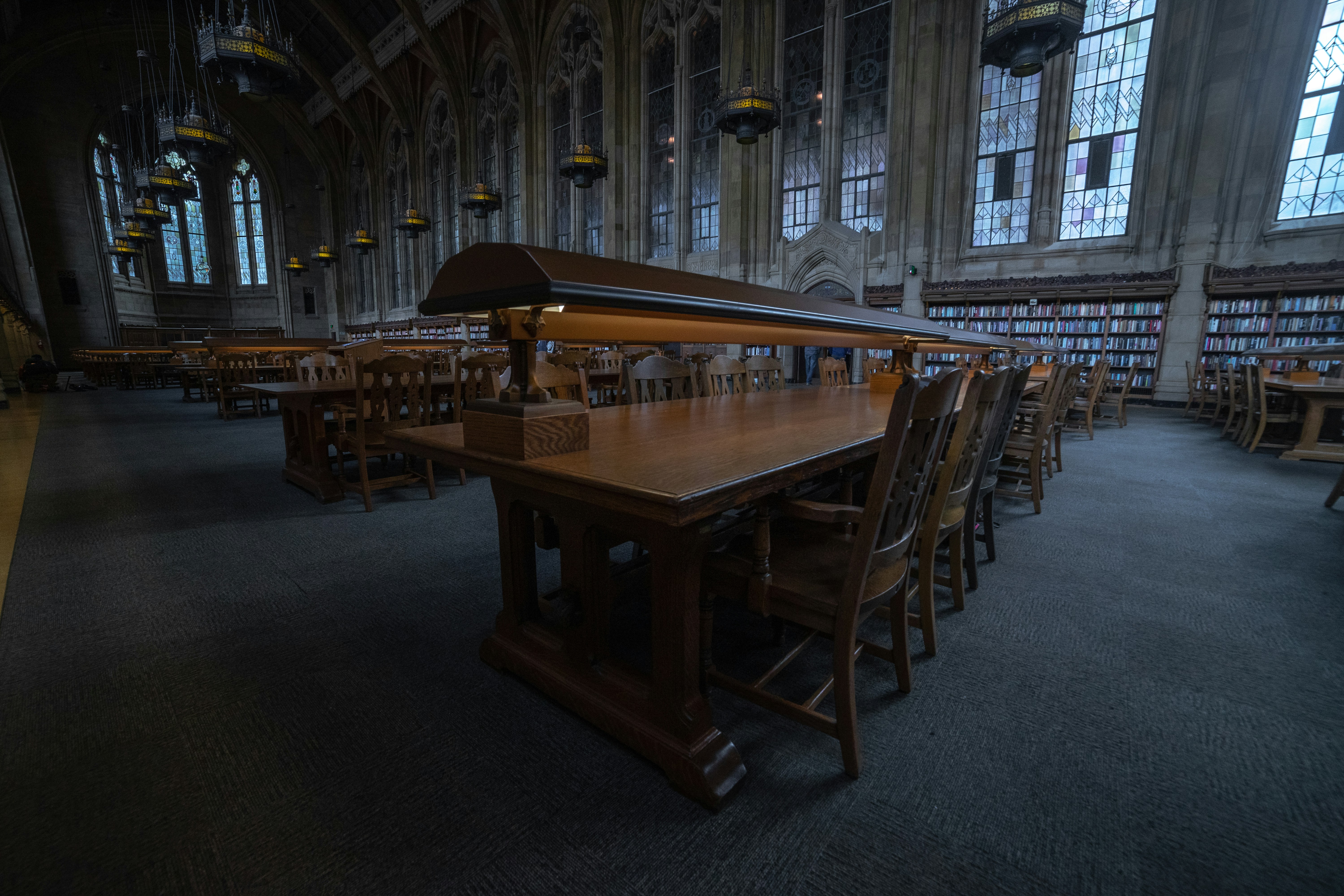 A long table in a large room with lots of chairs
