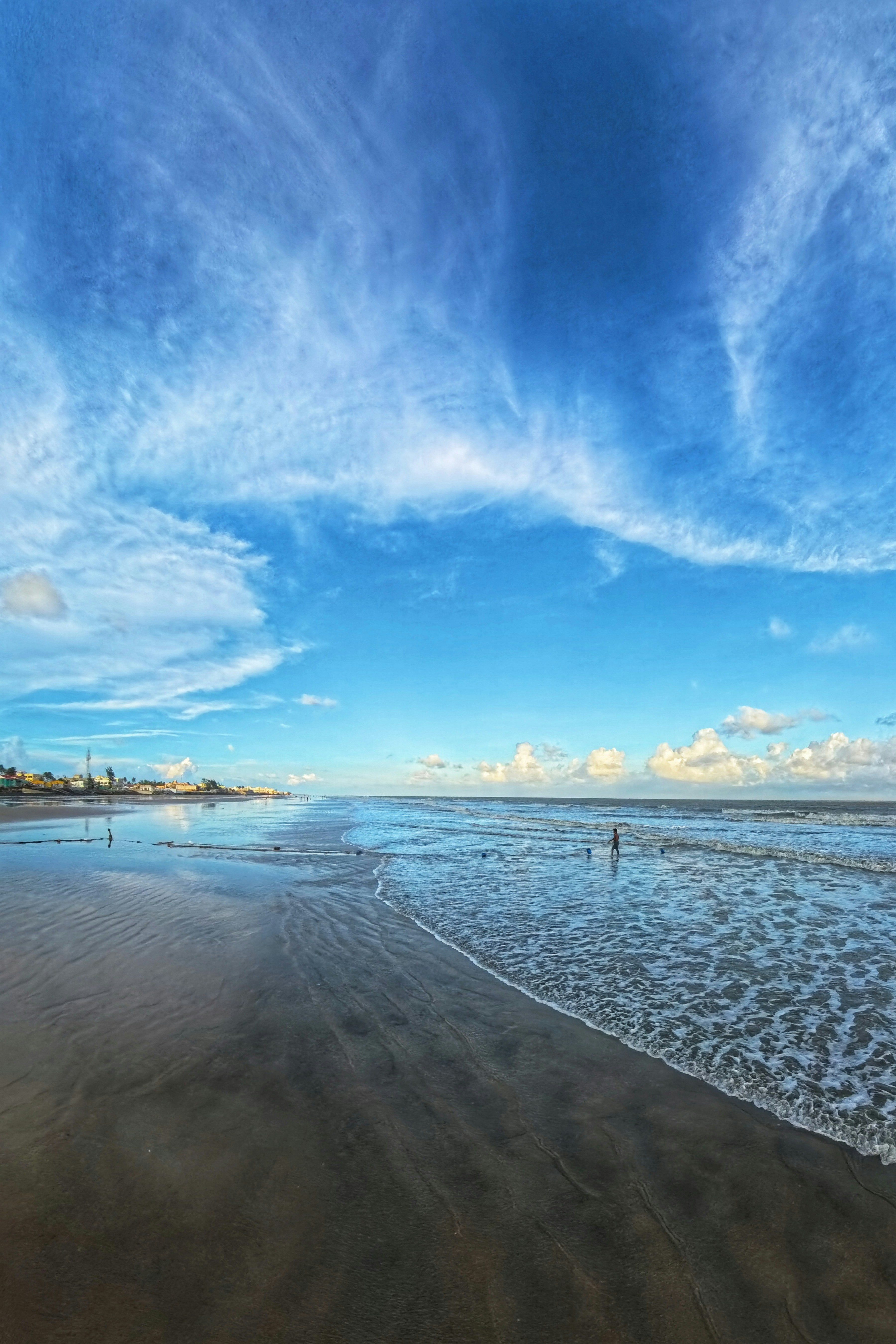 A person walking on a beach near the ocean