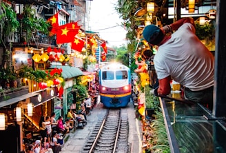 A train traveling down train tracks next to a crowd of people