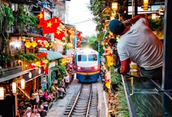 A train traveling down train tracks next to a crowd of people