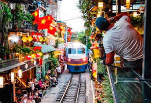 A train traveling down train tracks next to a crowd of people