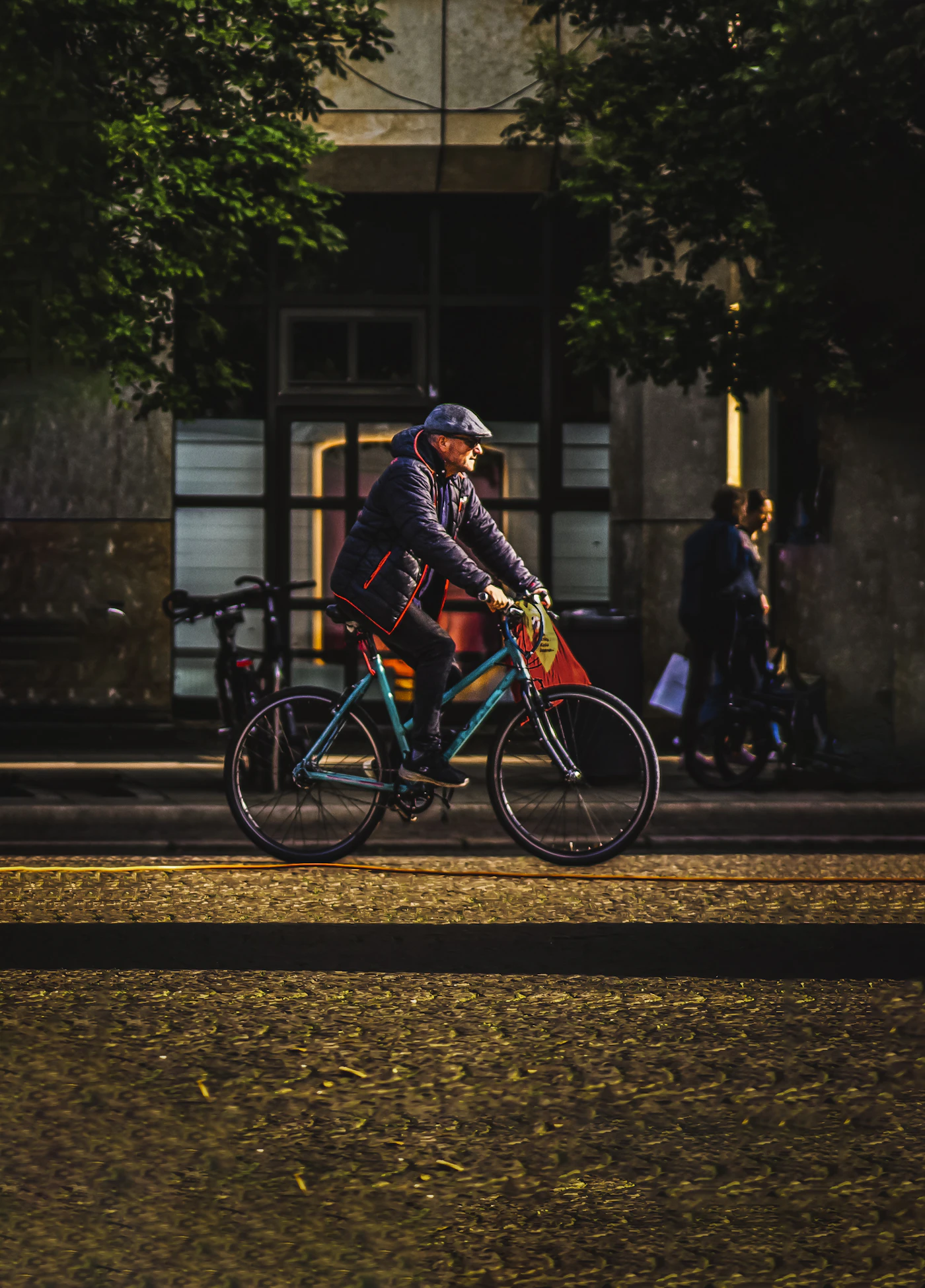 Man riding a bike down a city street in the evening