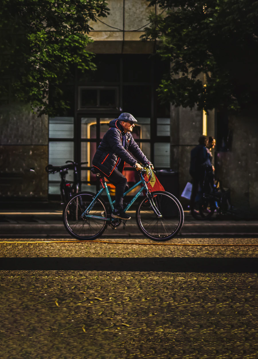 Man riding a bike down a city street in the evening